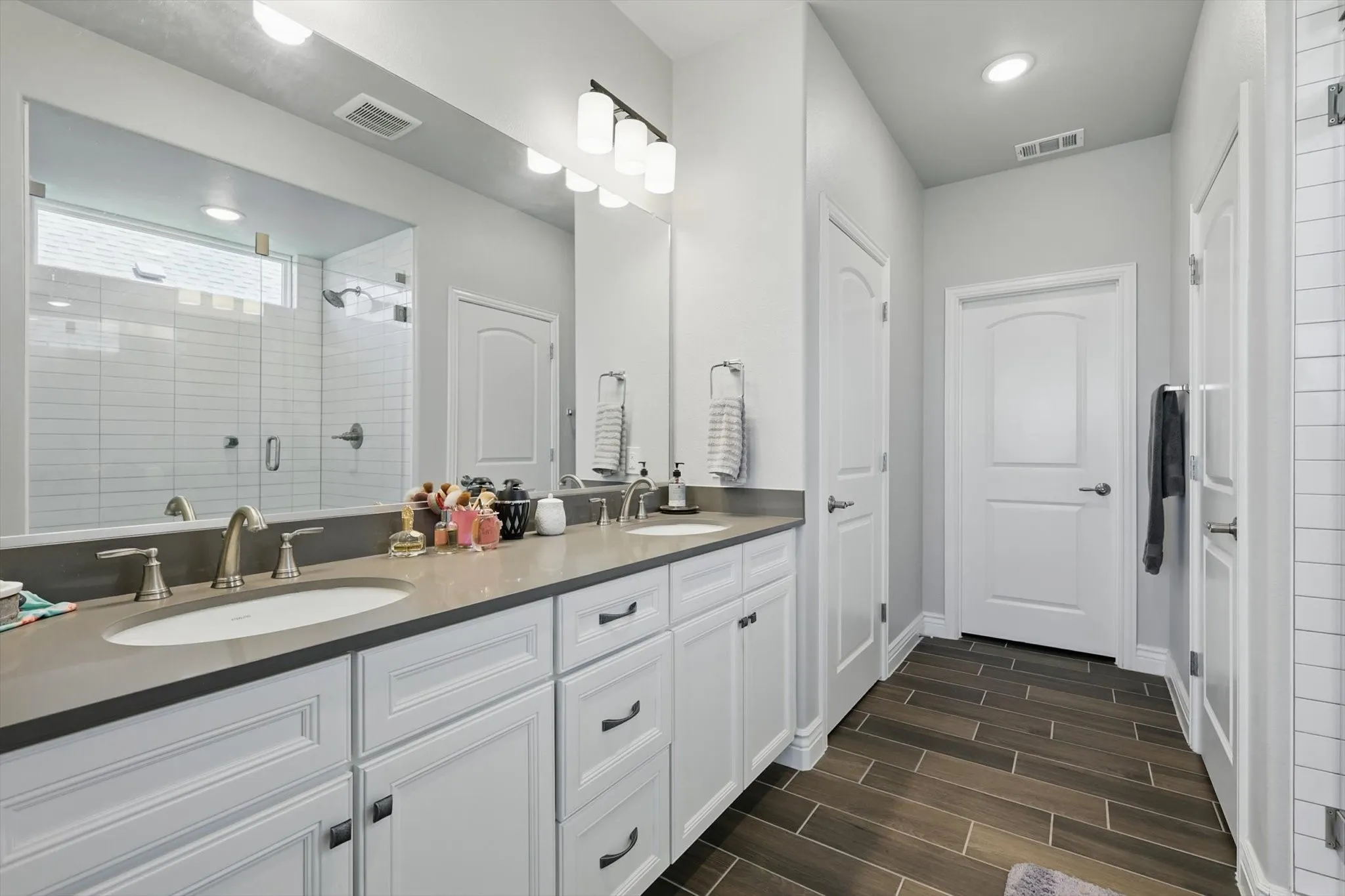 Bathroom with a double vanity, large linen closet, and walk-in closet with plug.