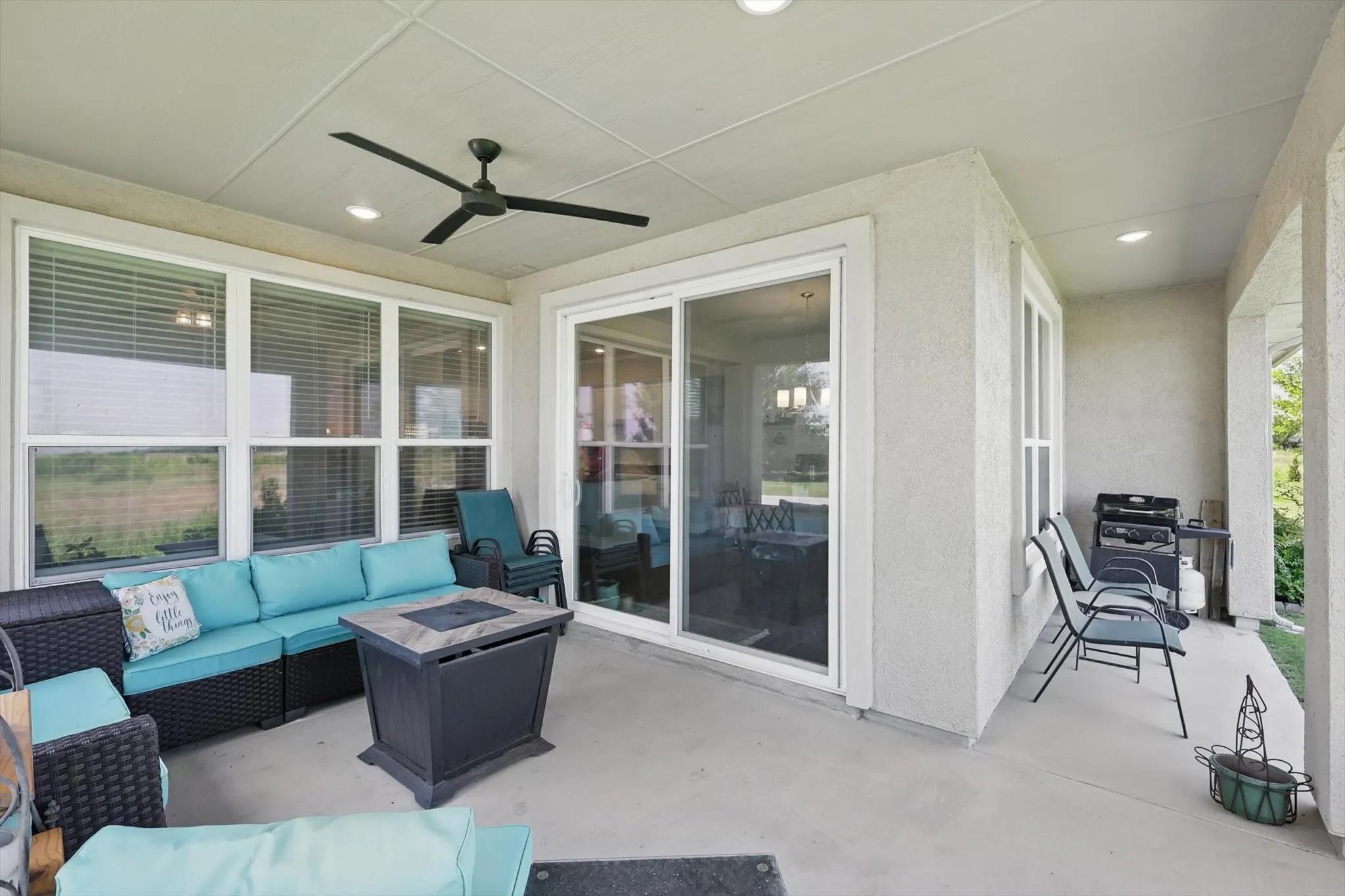 View of patio with an outdoor living space with a ceiling fan.