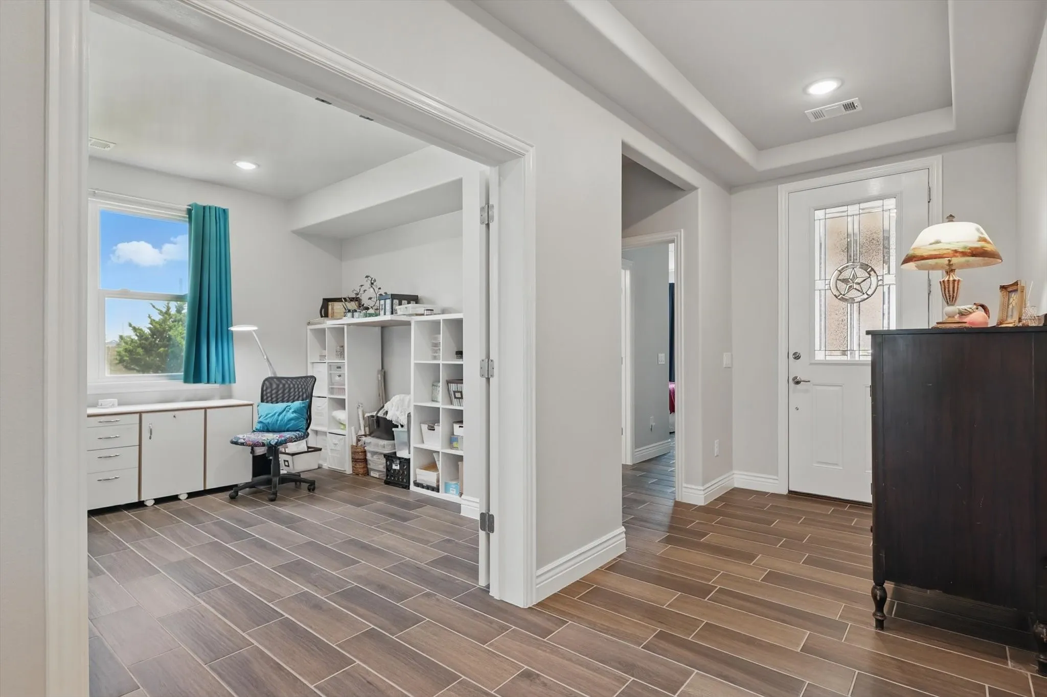 Office or craft room with tray ceiling and double doors for privacy.
