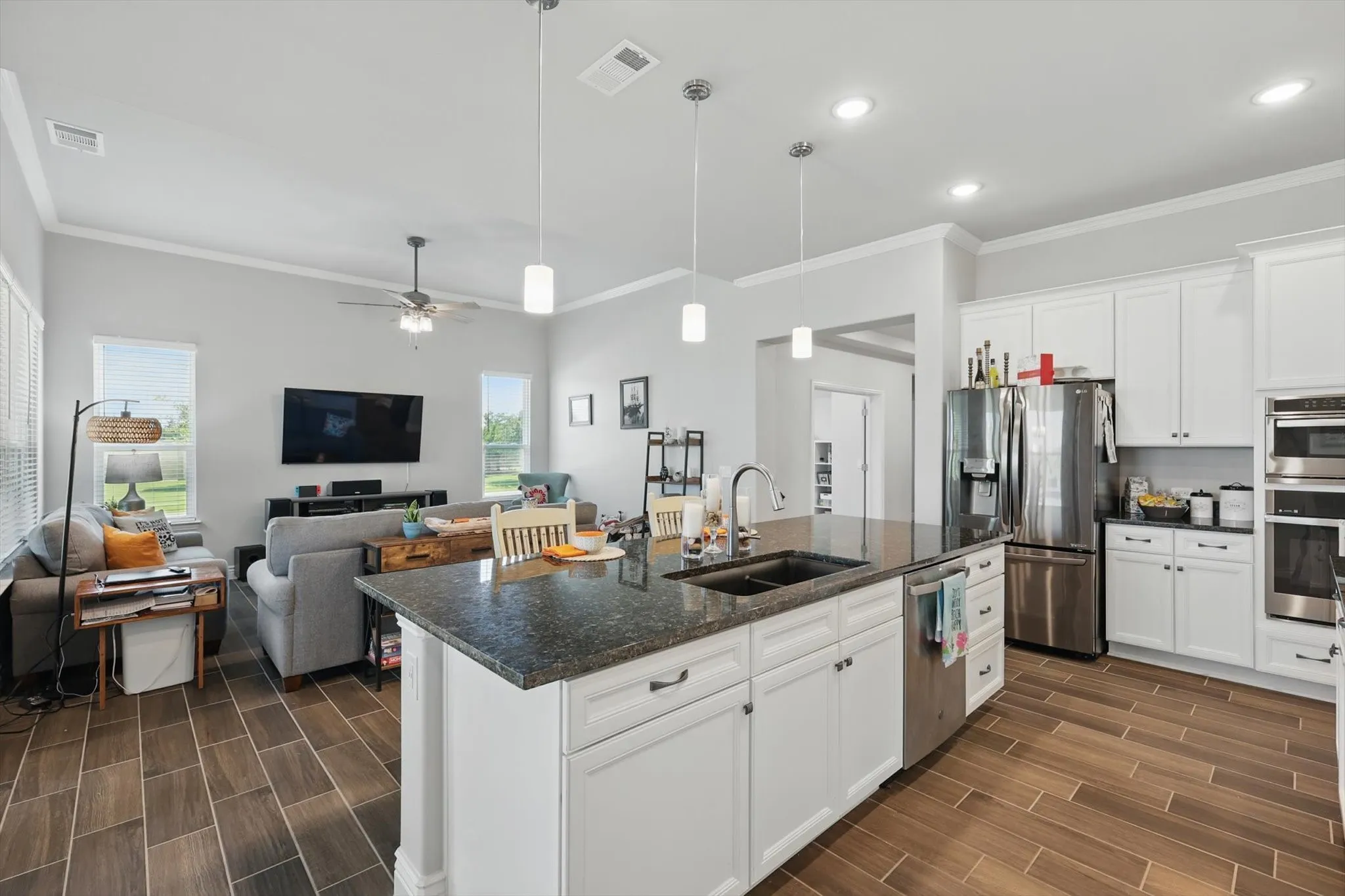 Kitchen with a black sink and stainless steel appliances.