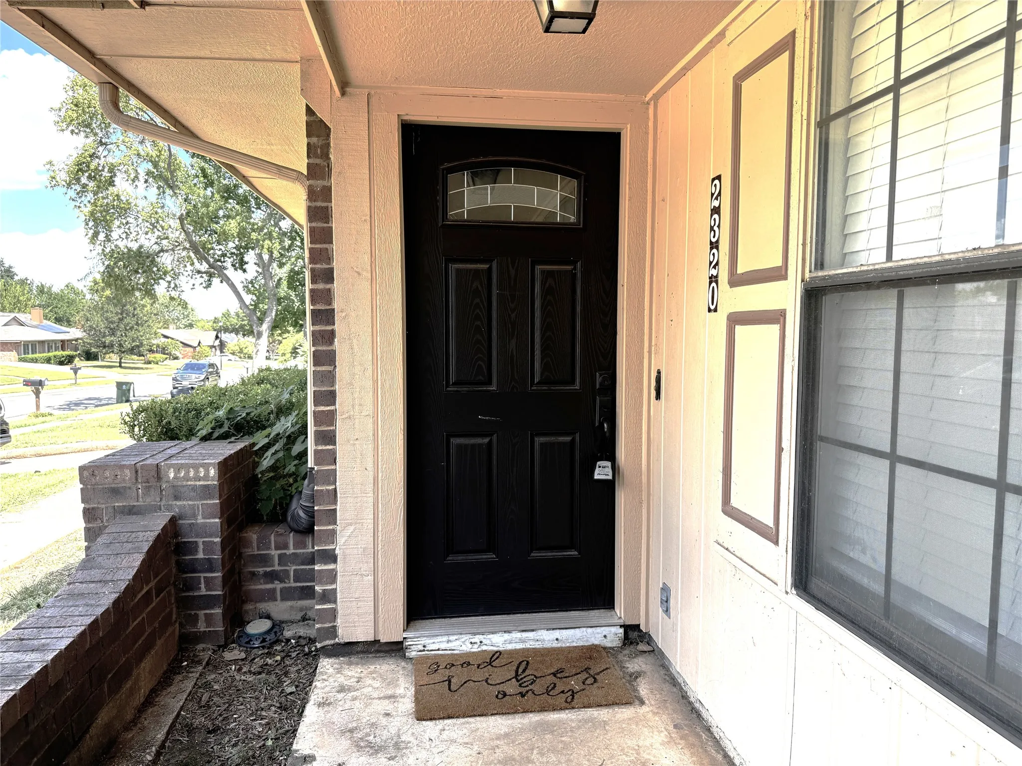 Black paneled entry door with transom window