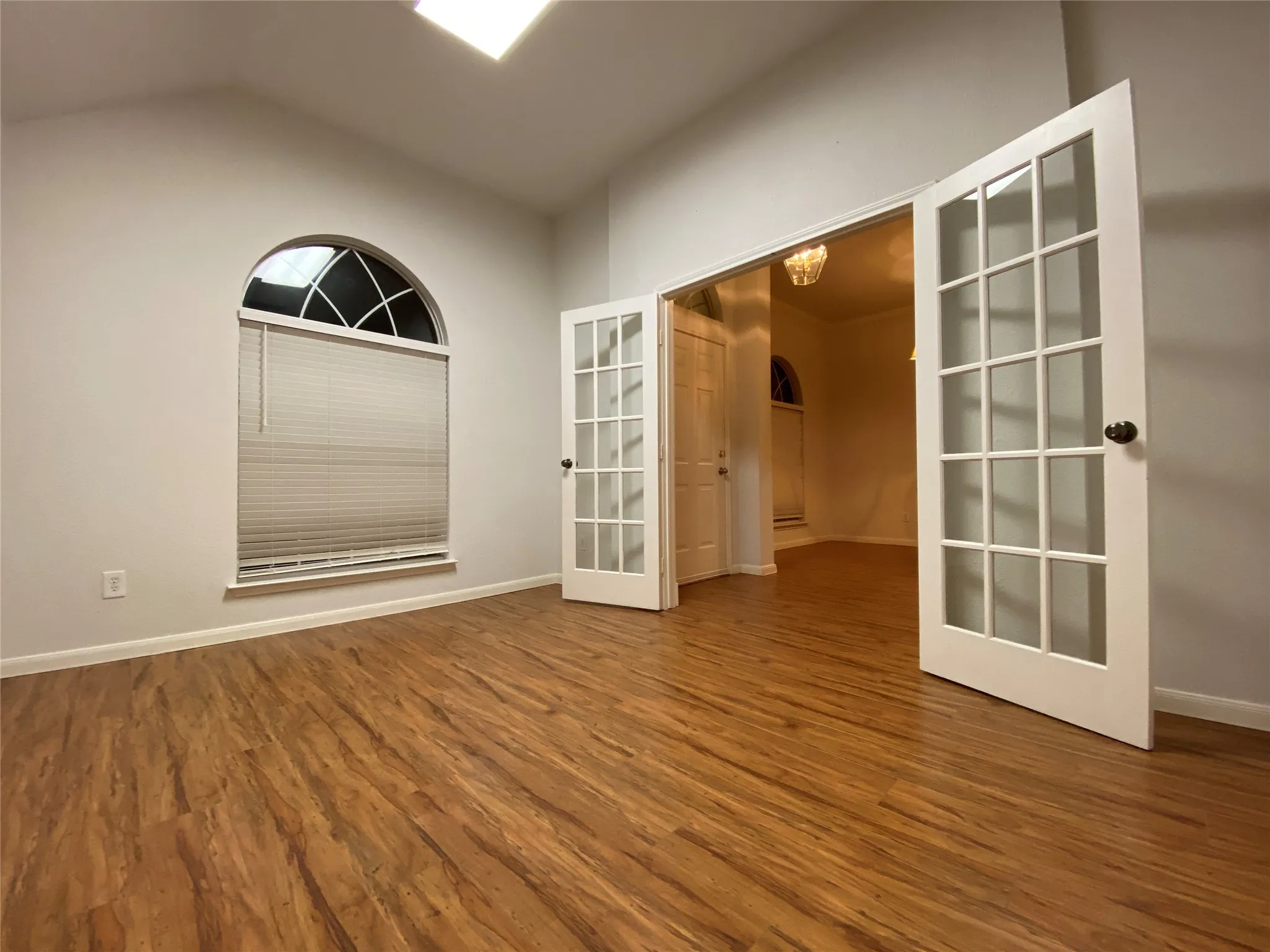 Unfurnished room with french doors, vaulted ceiling, and hardwood / wood-style floors