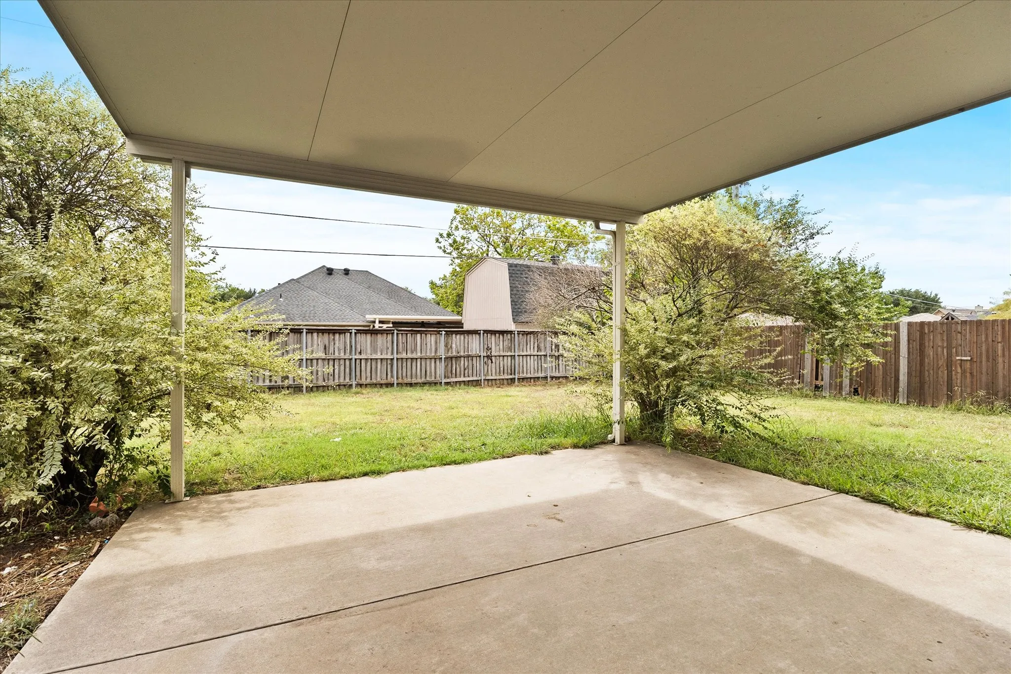 Expansive concrete patio with an overhead cover