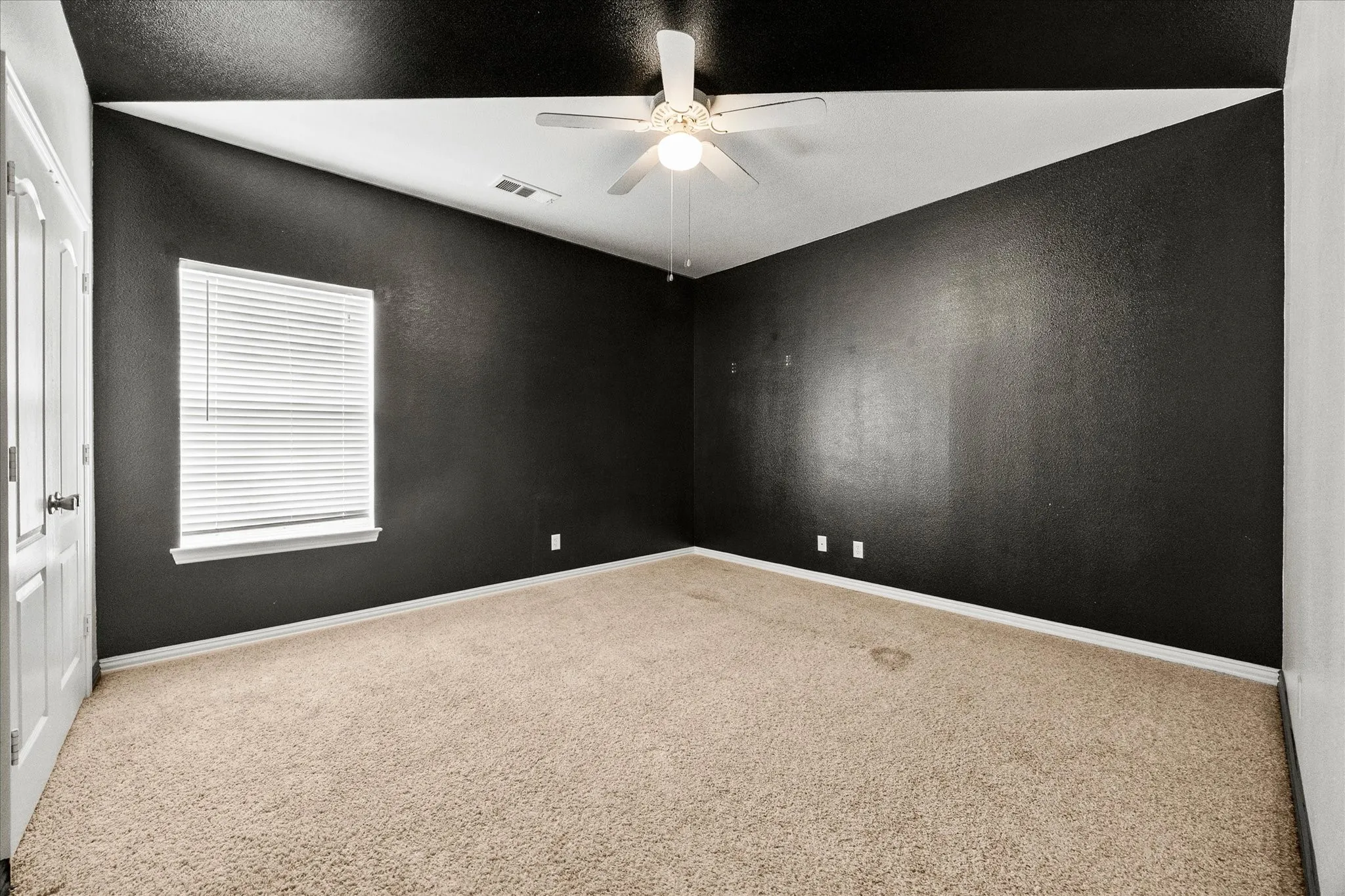 Carpeted flooring, vaulted ceiling, ceiling fan, window with blinds, and white trim
