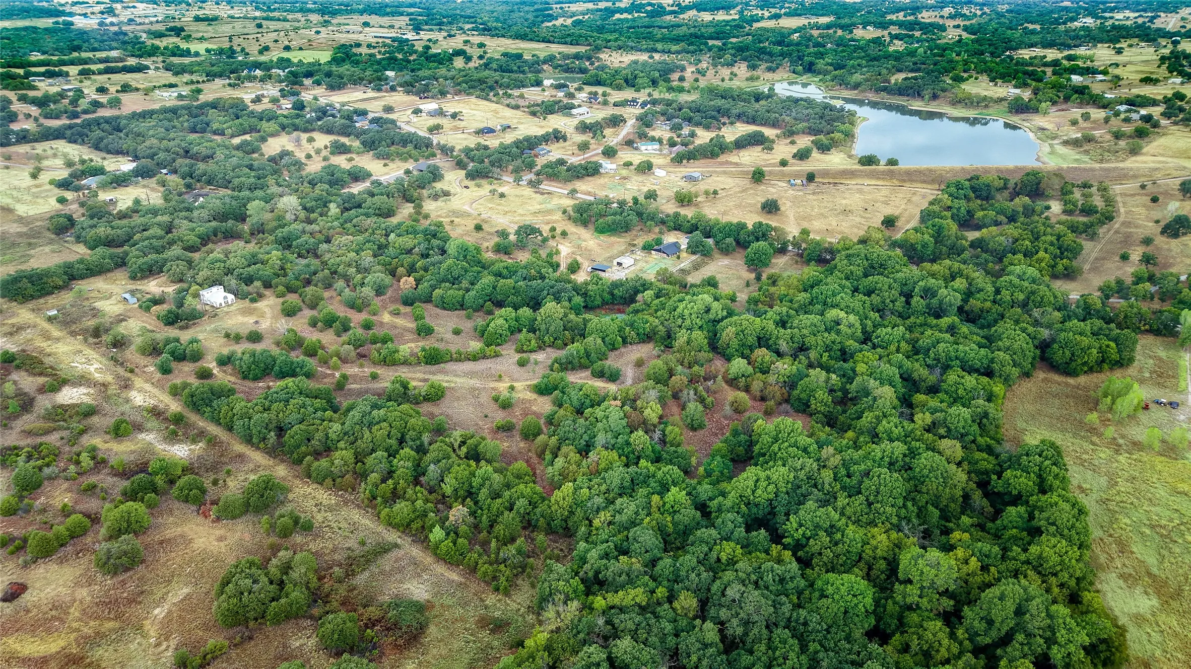 Expansive acreage featuring mature trees, open land, and a substantial body of water