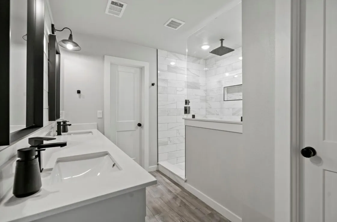 Bathroom featuring visible vents, a sink, and wood finished floors