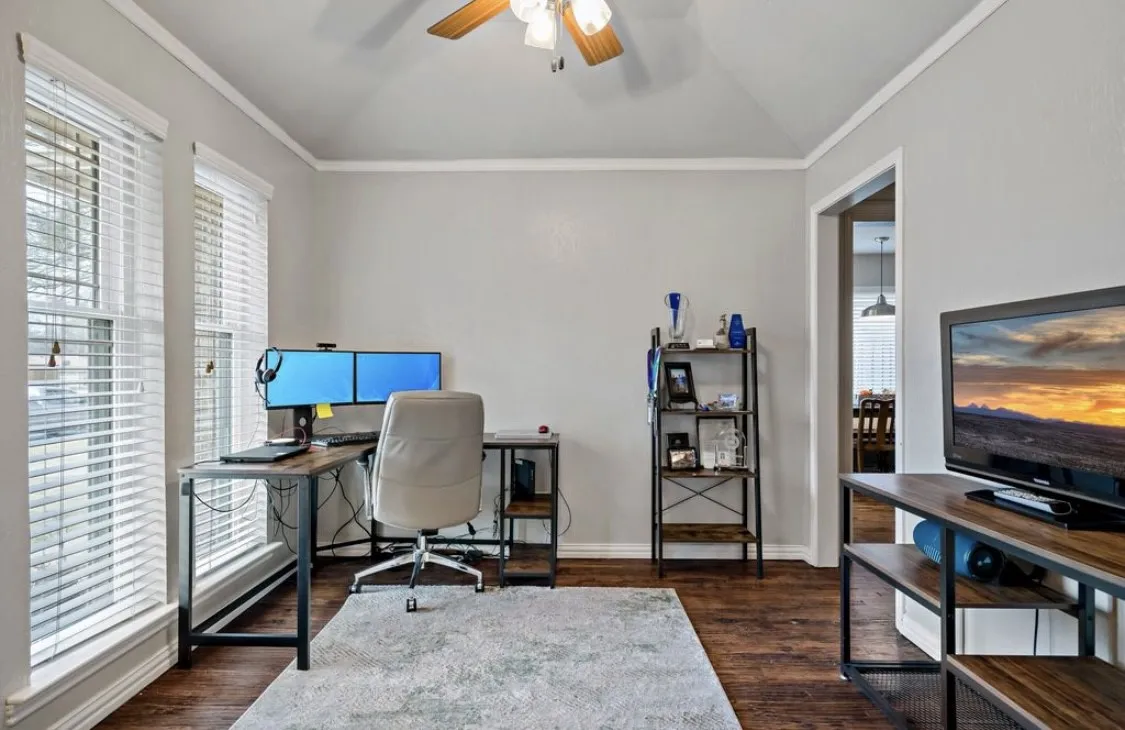 Office featuring ornamental molding, vaulted ceiling, ceiling fan, wood finished floors, and baseboards