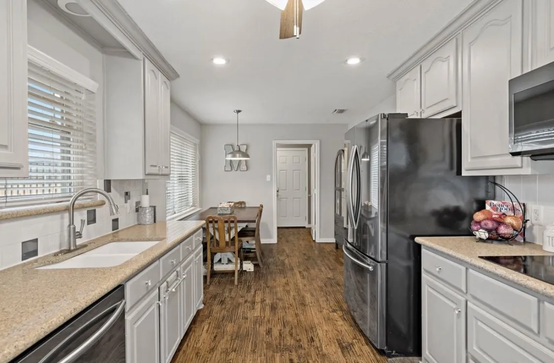 Kitchen featuring tasteful backsplash, dark wood-style floors, stainless steel appliances, a sink, and recessed lighting