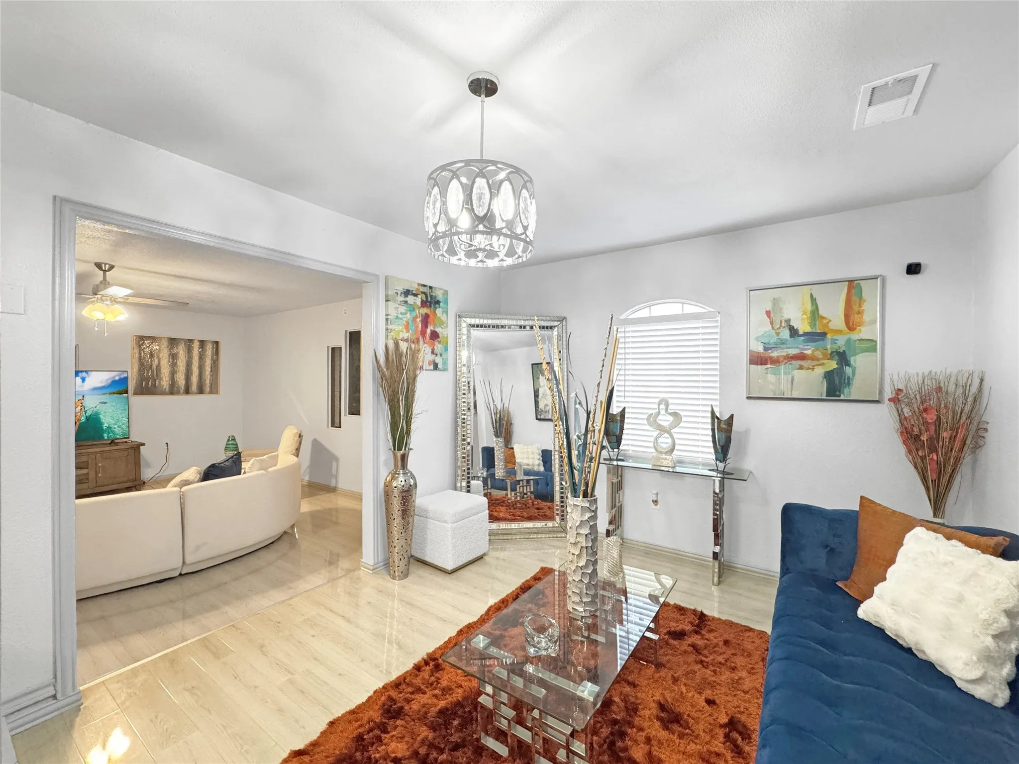 Recessed arch window, wood-finish flooring, contemporary chandelier, and a wide interior doorway