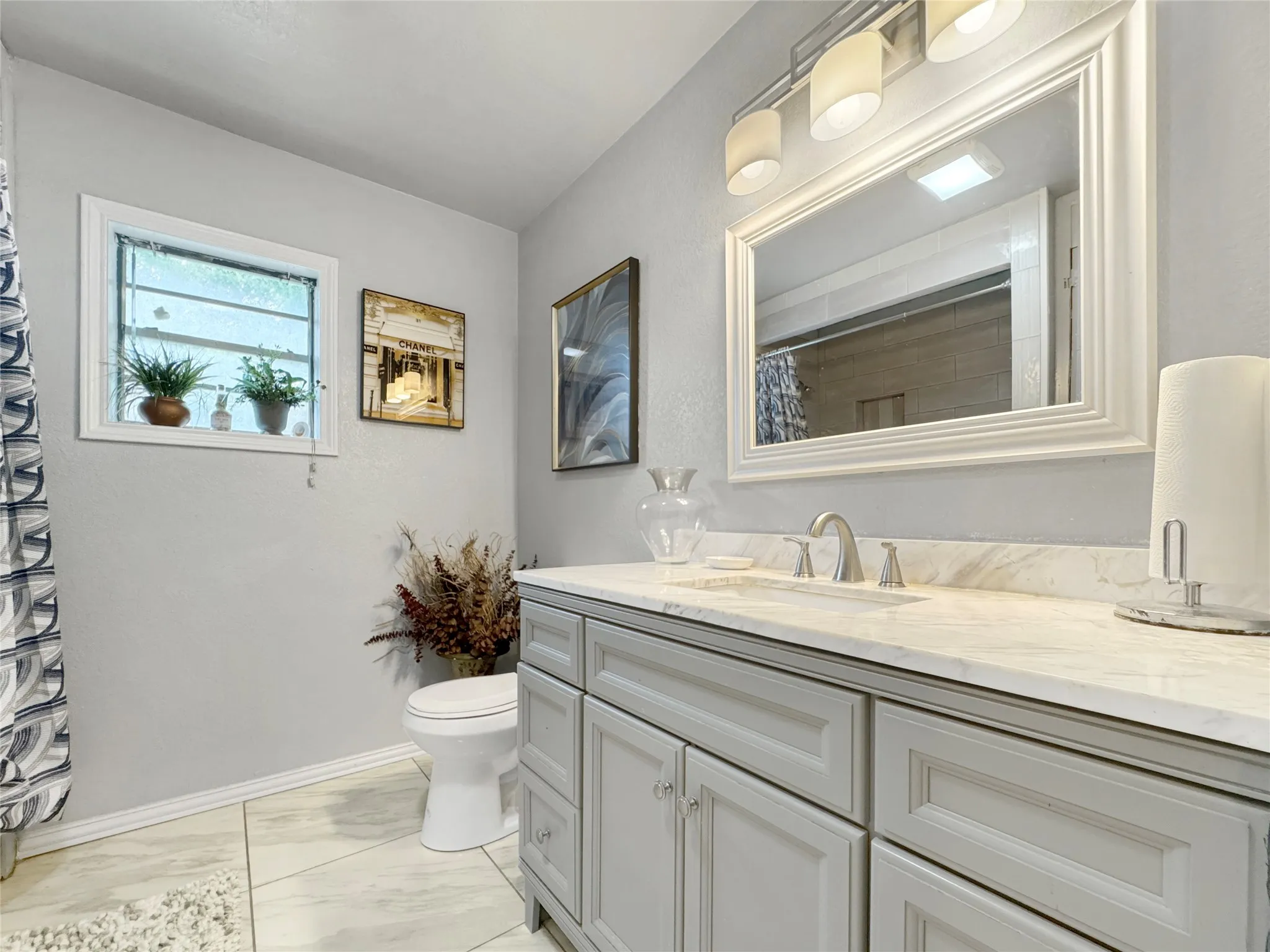 Grey shaker-style vanity with a light-toned countertop, undermount sink, and brushed nickel faucet