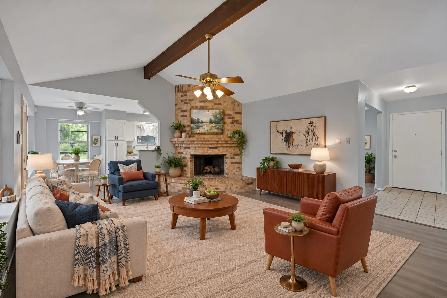 Family room: Corner brick fireplace, vaulted ceiling with exposed beam, and ceiling fan. Hallway access to the bedrooms. Virtually staged.