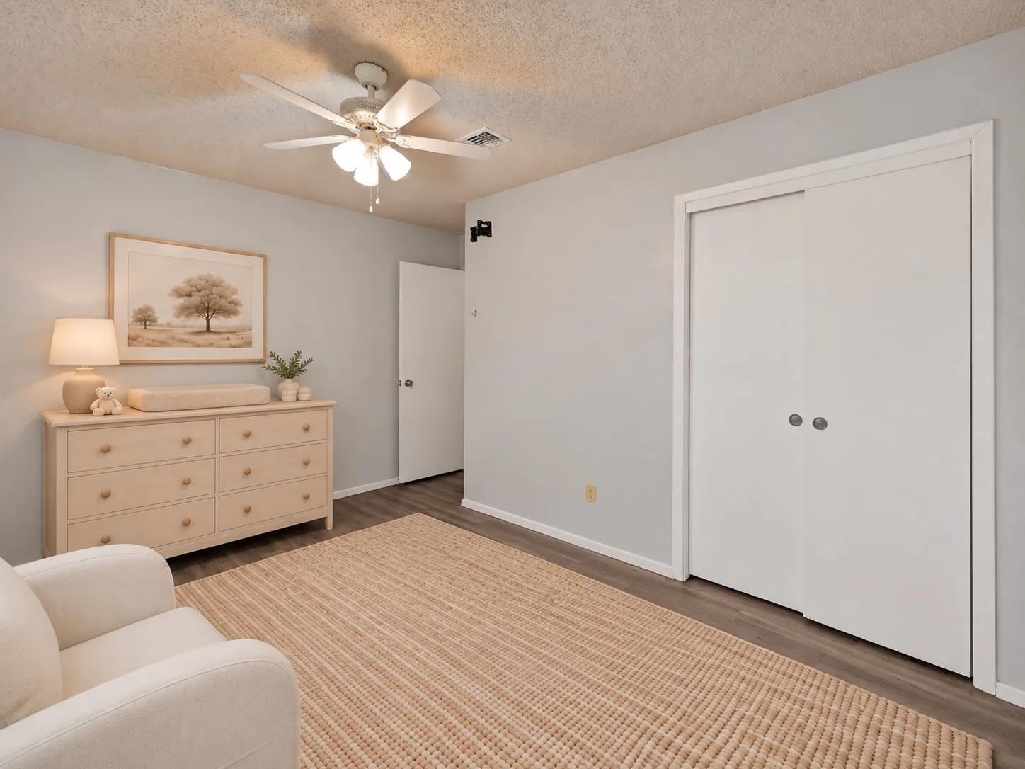 Secondary bedroom: Bedroom with sliding door closet, ceiling fan, and wood-look plank flooring. Virtually staged.
