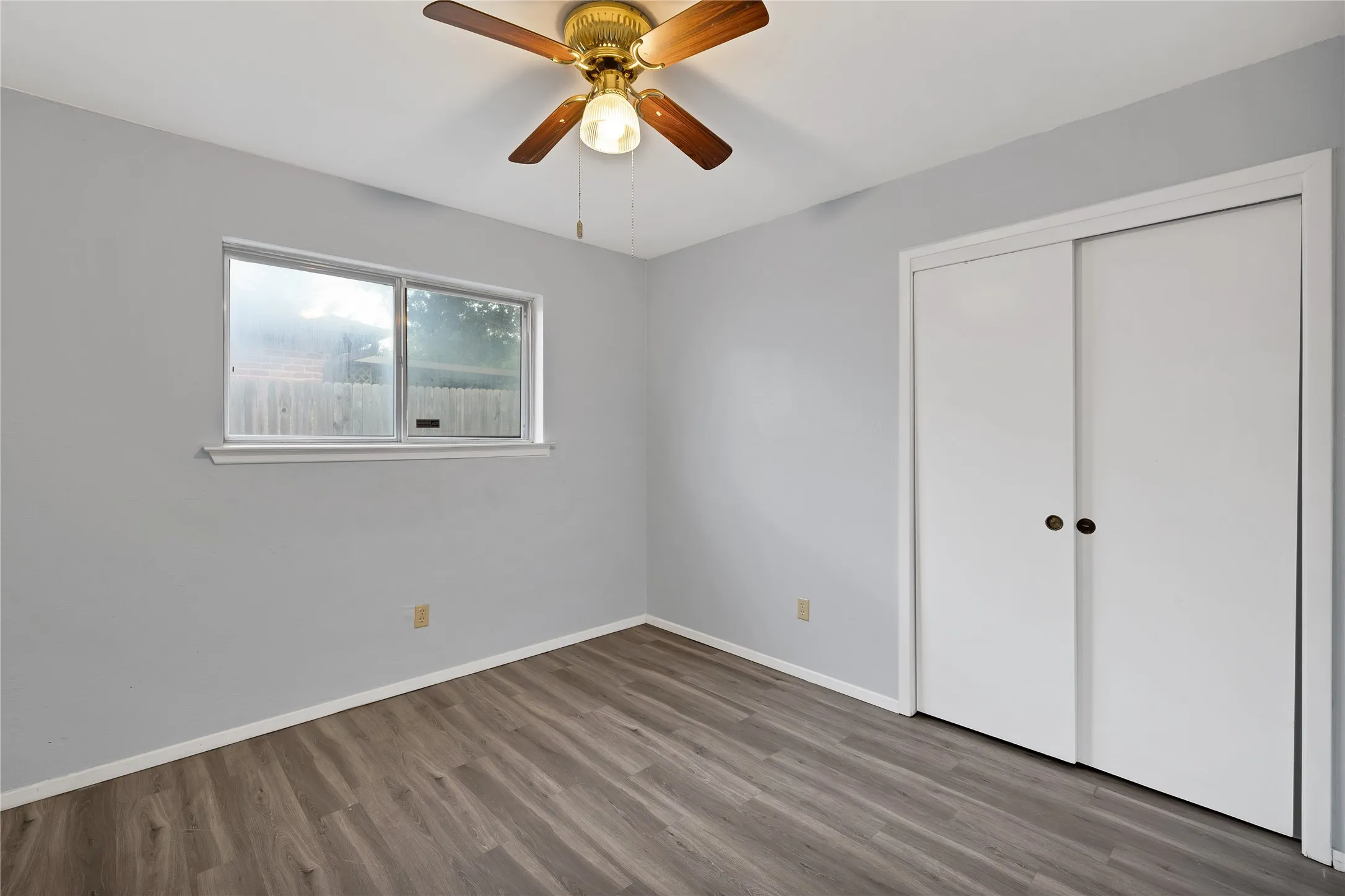 Bedroom: Bedroom with sliding door closet, ceiling fan, and window.