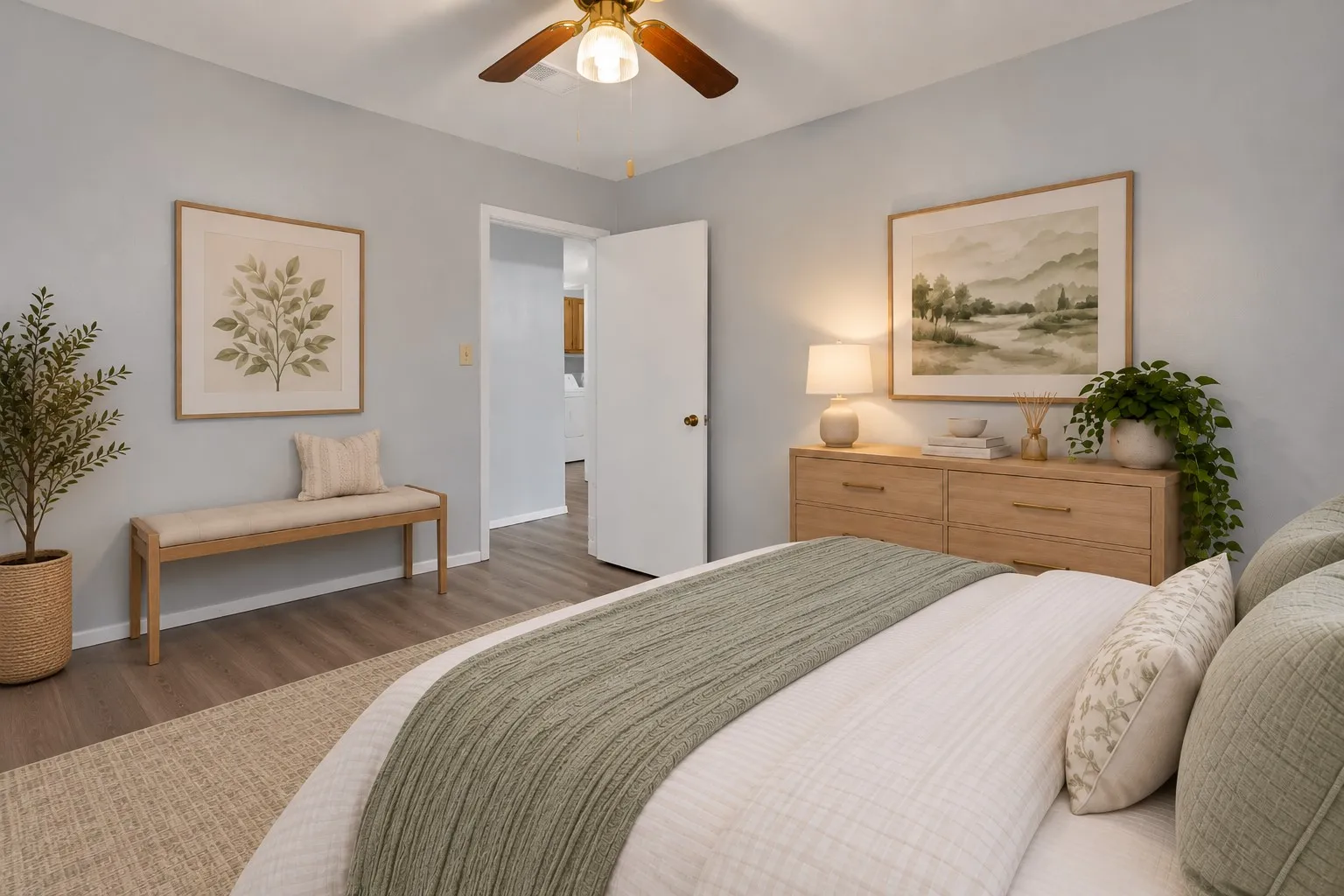 Bedroom: Bedroom with ceiling fan, wood-look plank flooring, and doorway to the hall. Virtually staged.