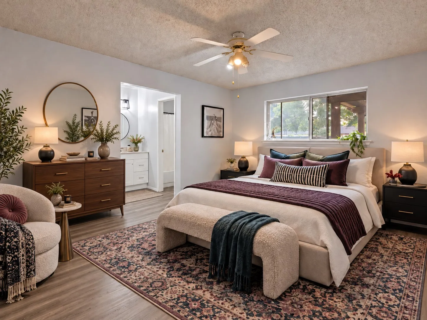 Primary bedroom: Primary bedroom with ceiling fan, wood-look plank flooring, and ensuite bath with white vanity. Virtually staged.