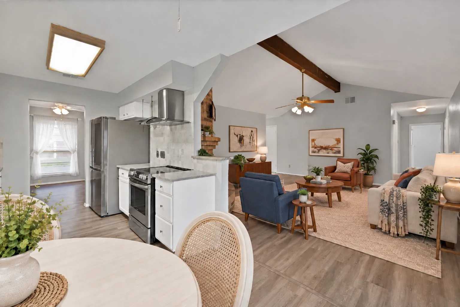 Kitchen and family room: Open sightline from the breakfast area through the kitchen to the family room with vaulted ceiling and exposed beam. Virtually staged.