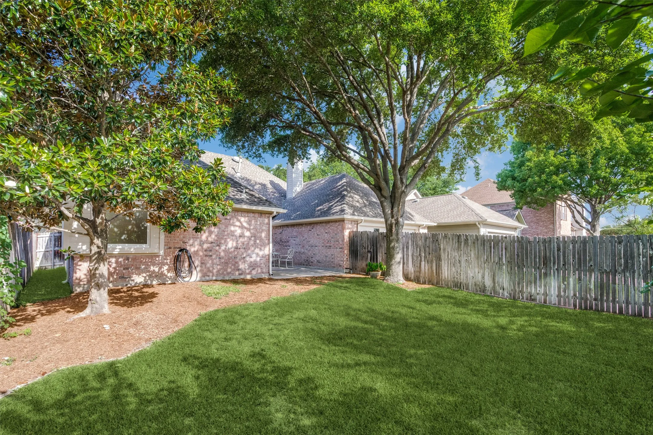 Fenced backyard with open patio