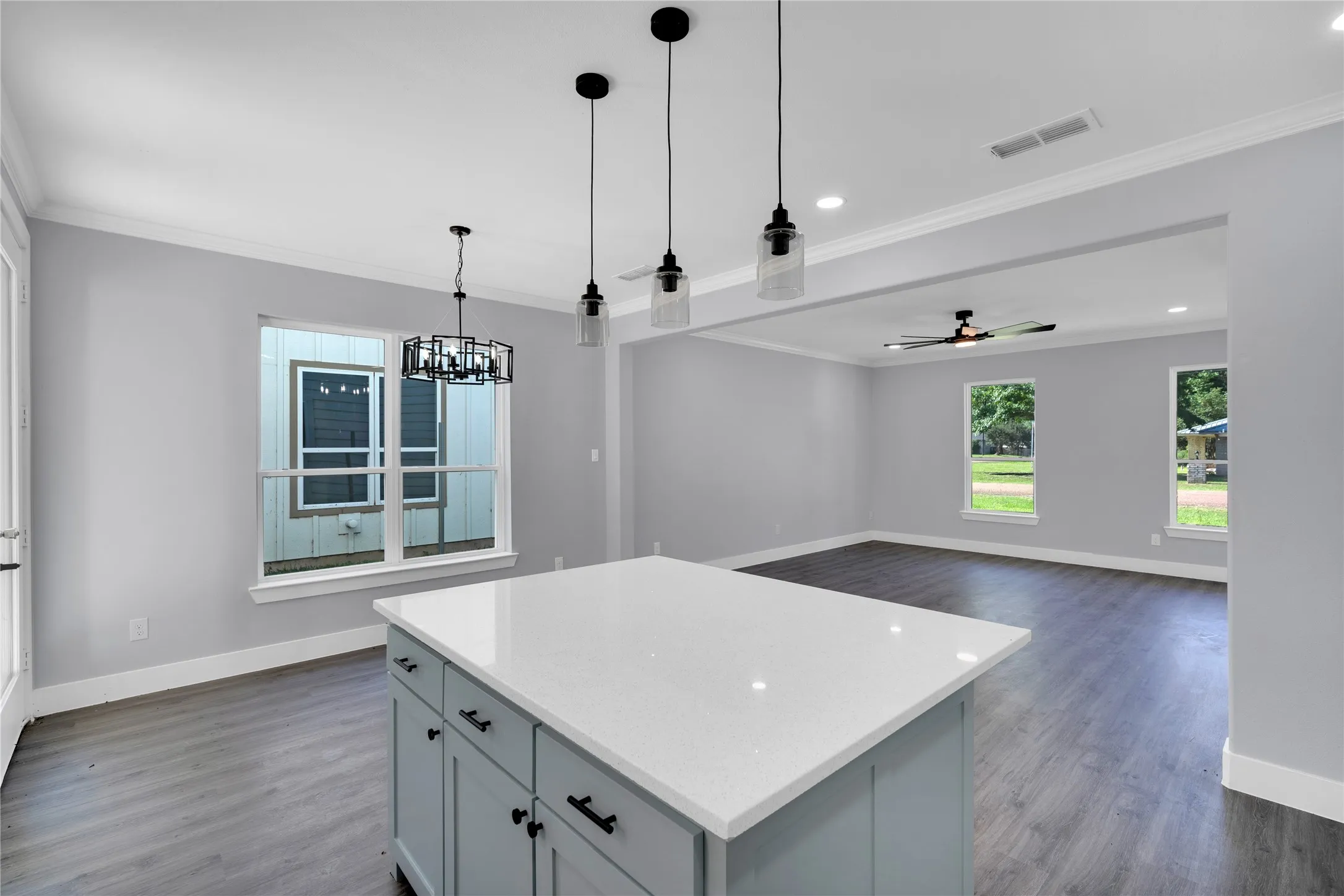 Kitchen island featuring a white countertop and light blue cabinetry, with wood-finish flooring throughout