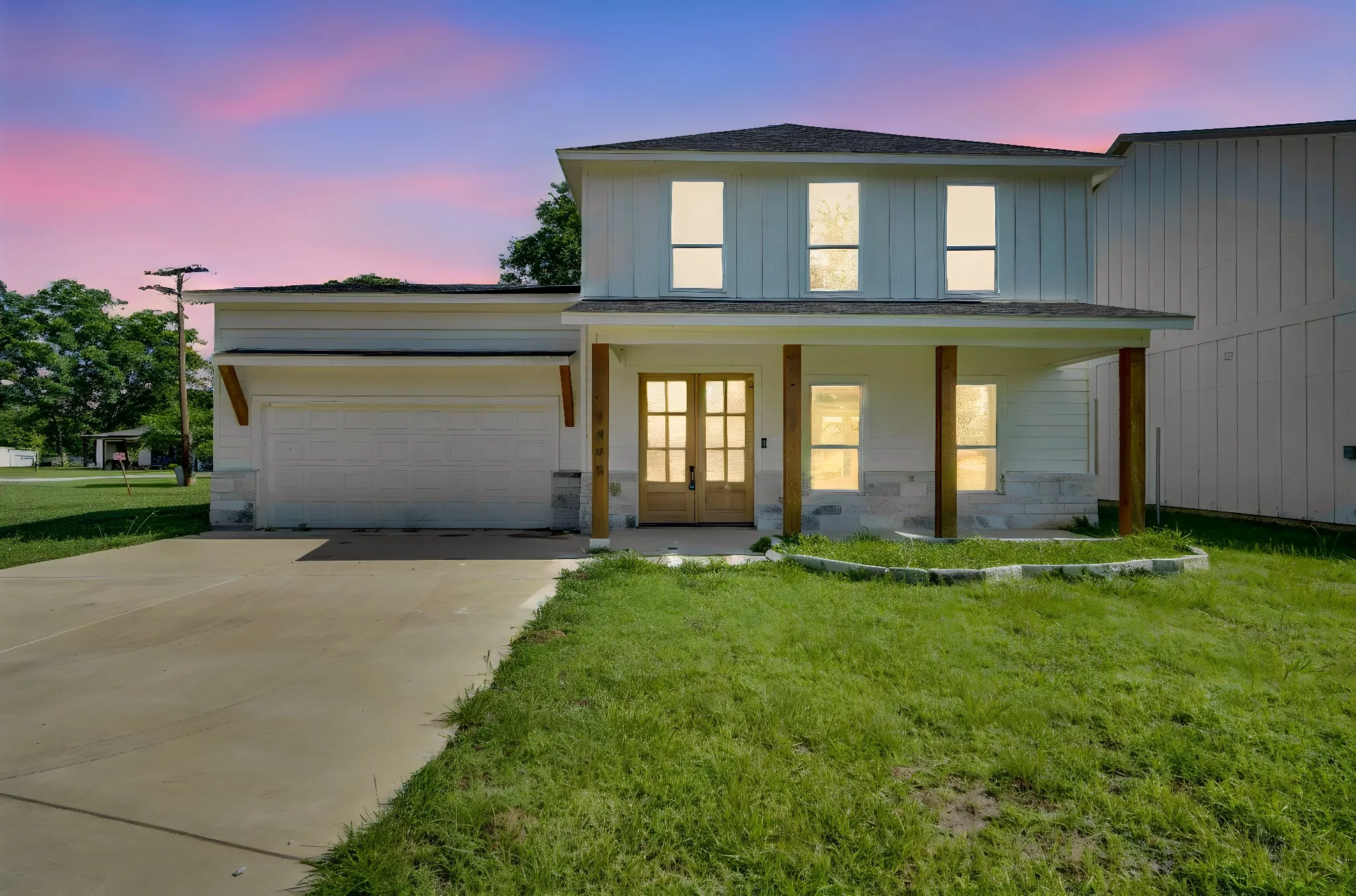 Contemporary exterior featuring board and batten siding, a covered front porch, and a stone accent facade