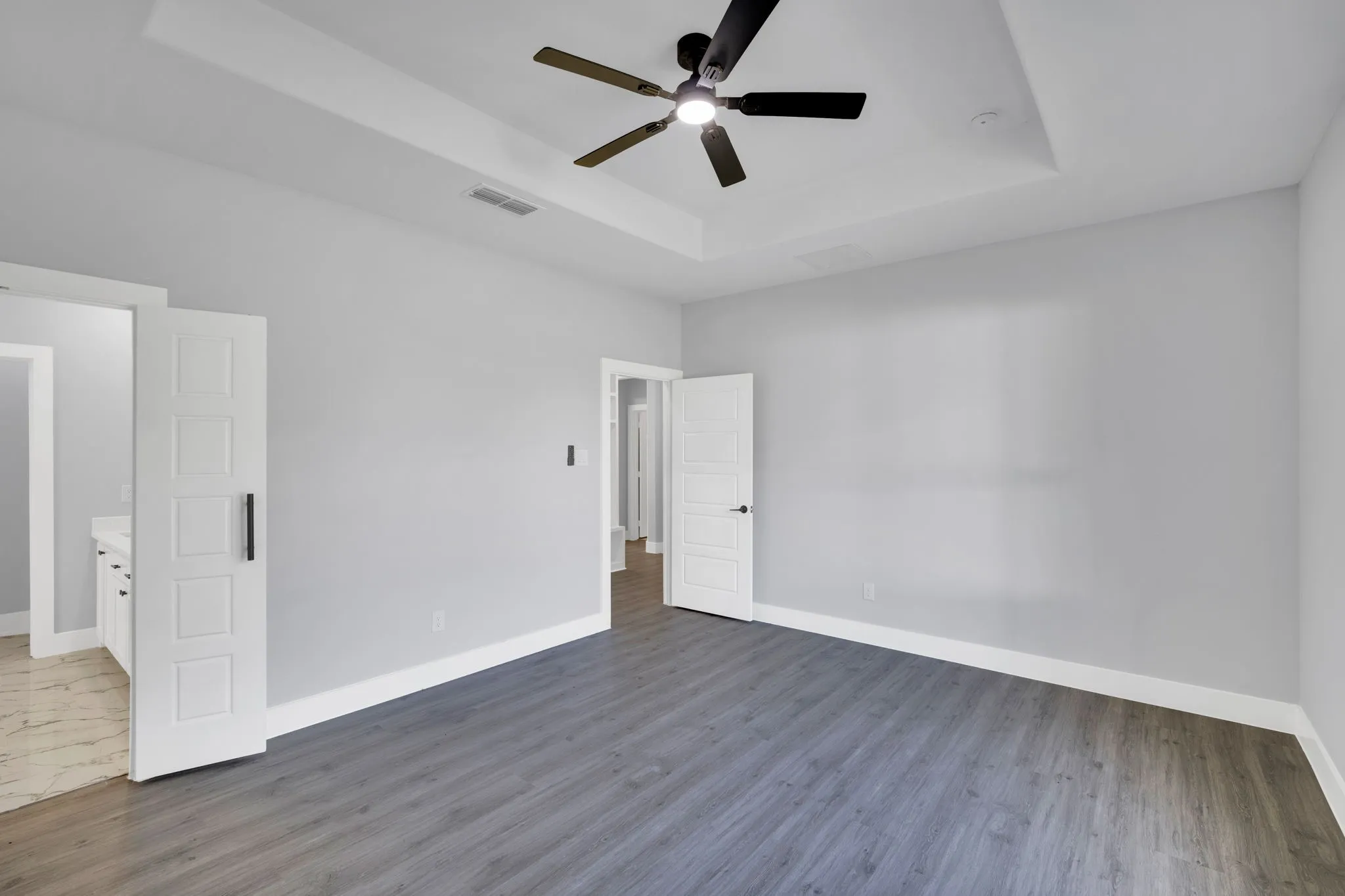 Tray ceiling with a recessed light fixture and a ceiling fan