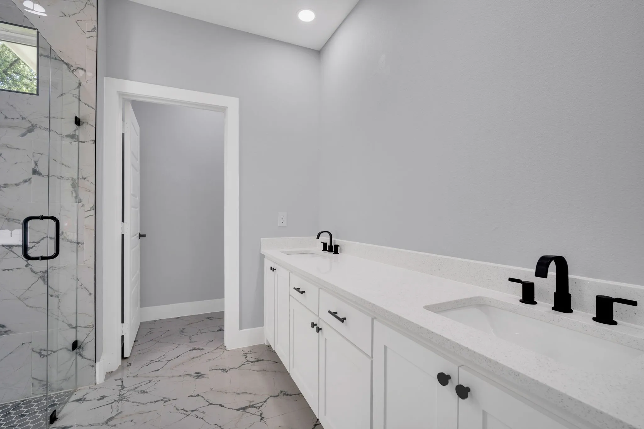 Dual vanity with solid surface countertop, undermount sinks, and matte black fixtures