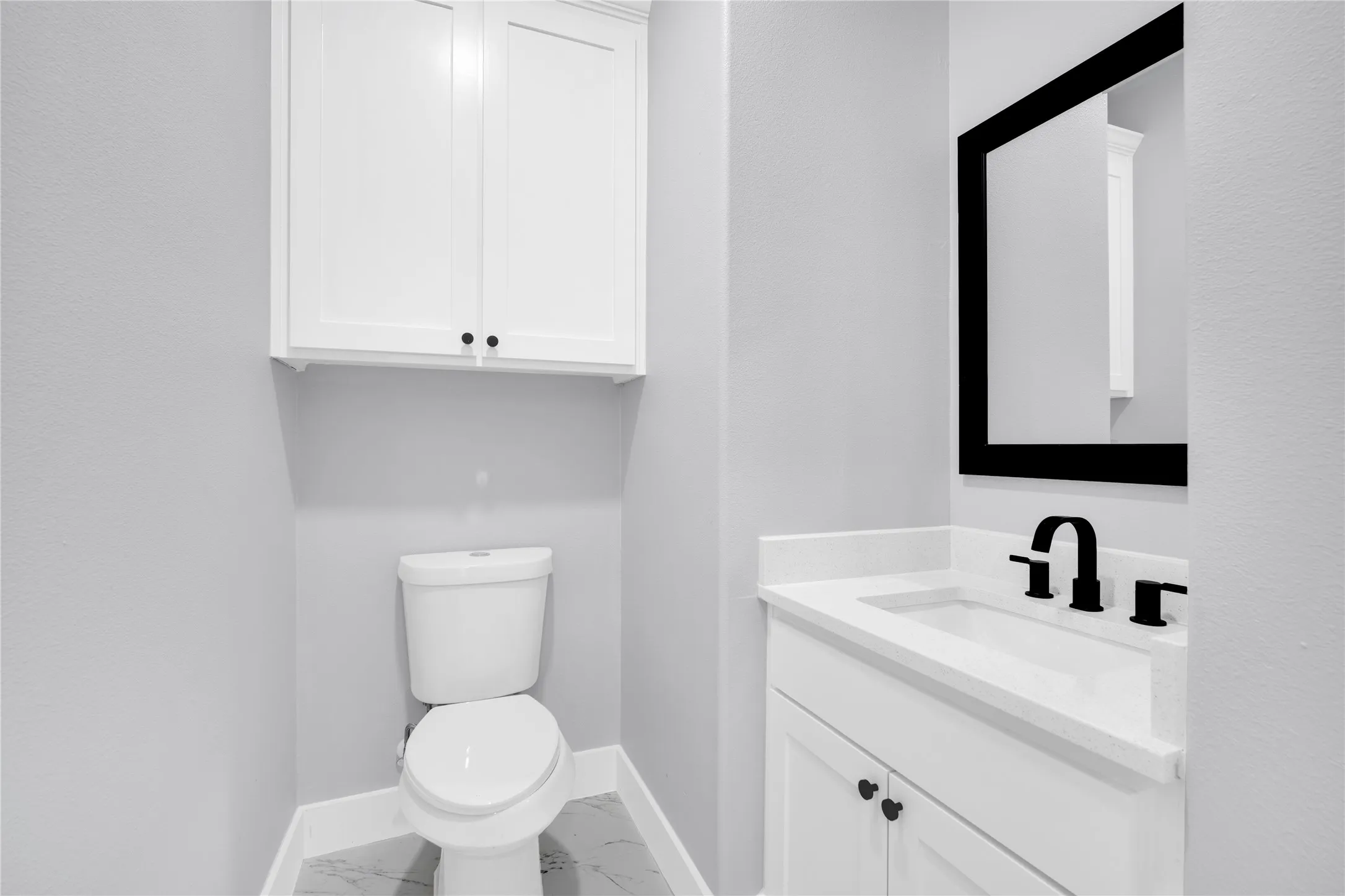 White vanity with an integrated sink and matte black faucet