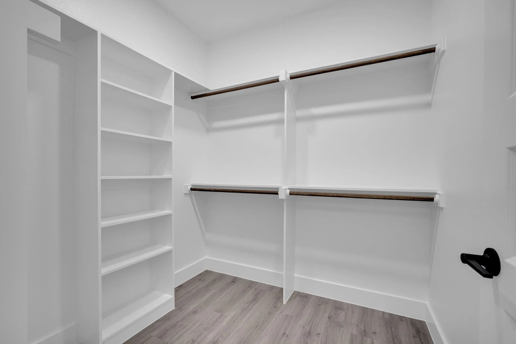 Built-in shelving, dual hanging rods, white finishes, and wood-finish​​‌​​​​‌​​‌‌​‌‌​​​‌‌​‌​‌​‌​​​‌​​ flooring