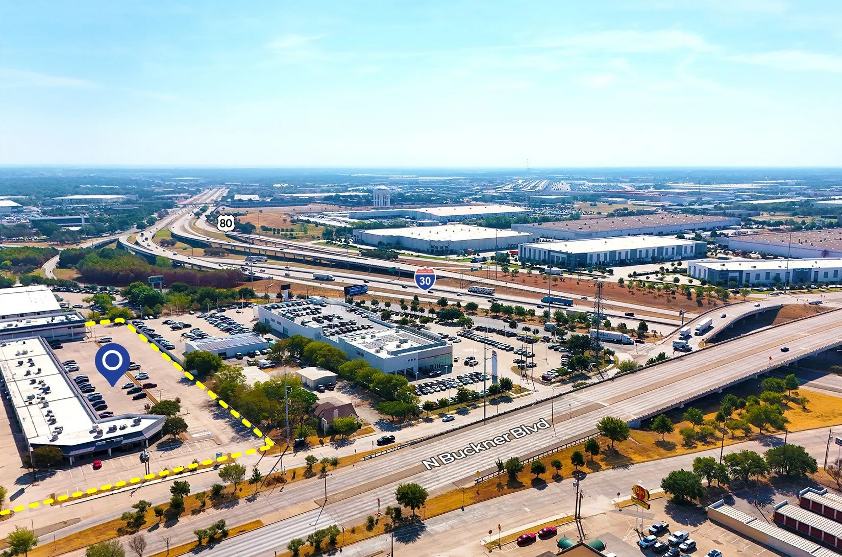 Property featuring a large parking area, direct access to N Buckner Blvd, and proximity to major highways I-30 and 80
