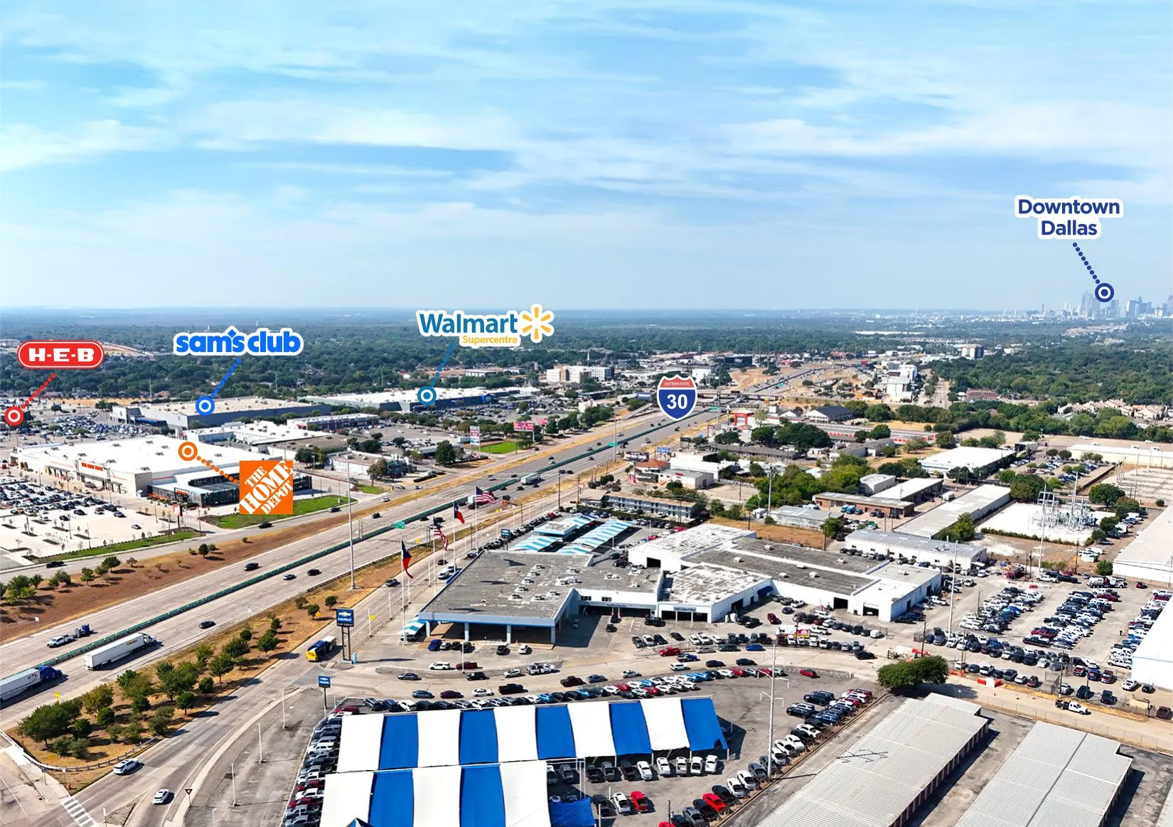 Aerial perspective with Interstate 30, visible retail centers including H-E-B, Sam's Club, Walmart, and The Home Depot, and the distant Dallas skyline