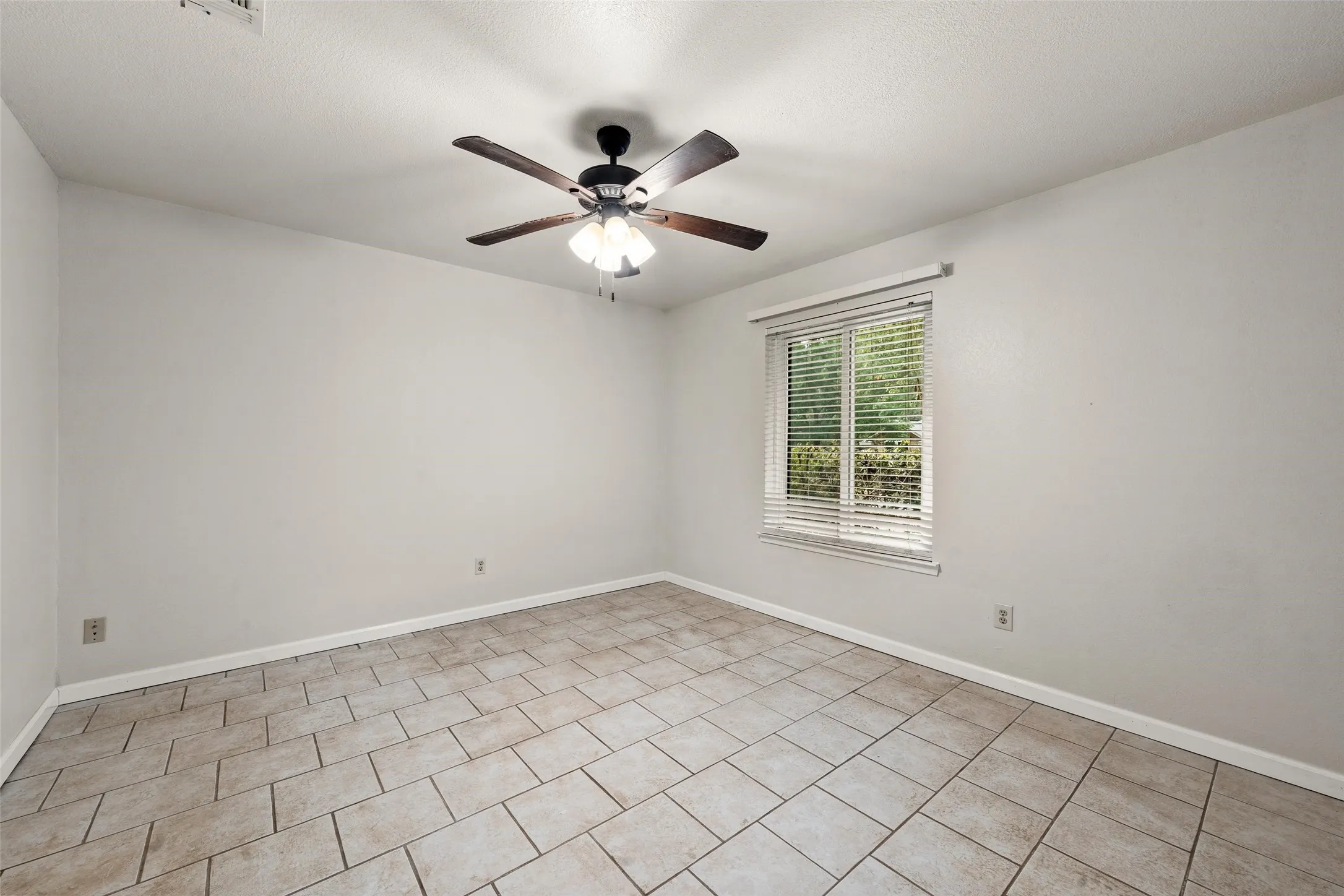 Tiled flooring, ceiling fan with integrated lighting, and a window with blinds