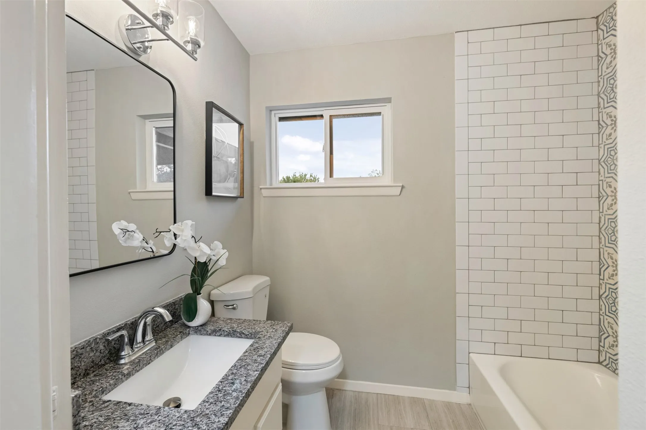 Hall bathroom with a new granite top, faucet, light fixture and toilet