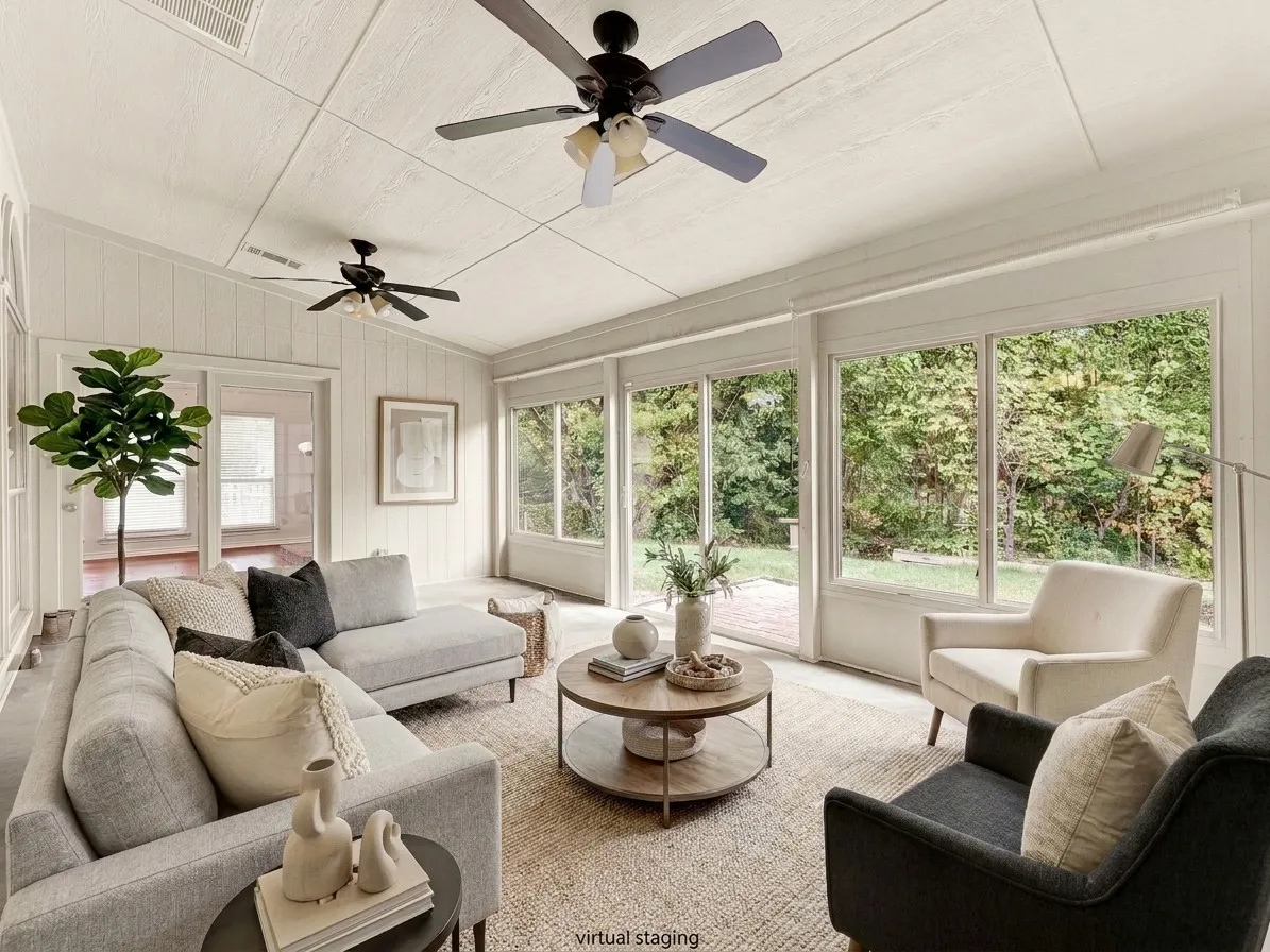 Enclosed sunroom / flex space features a wall of windows overlooking the private backyard