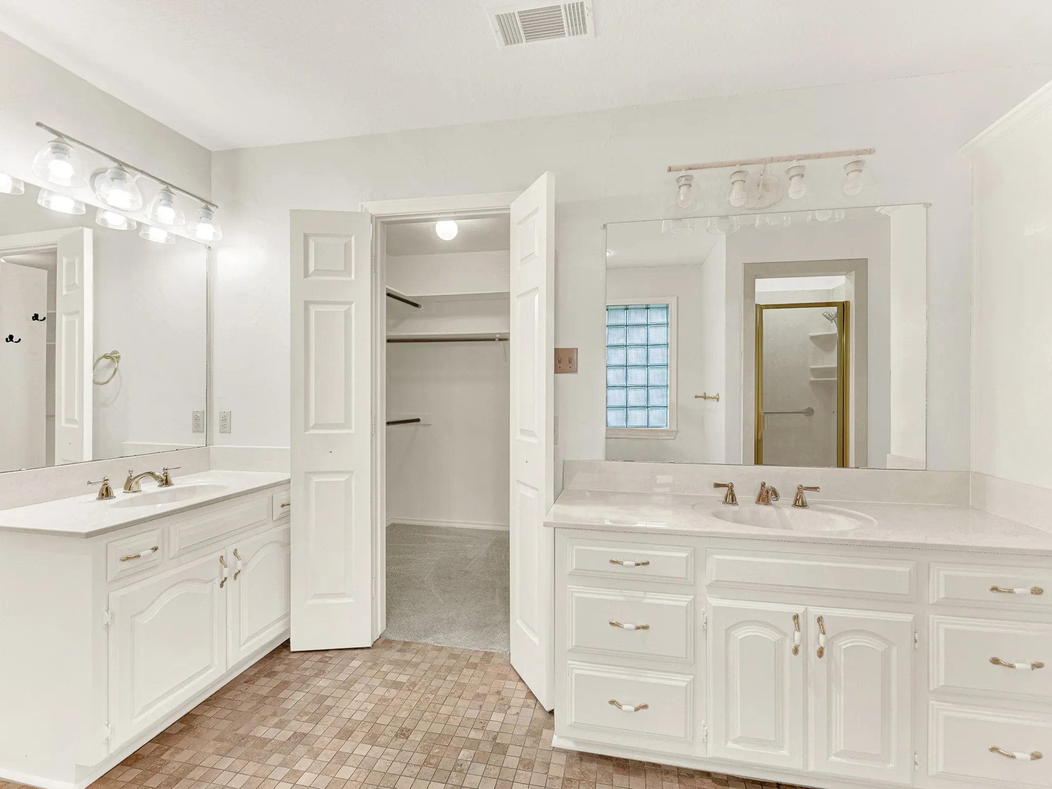 Primary bathroom features separate vanities