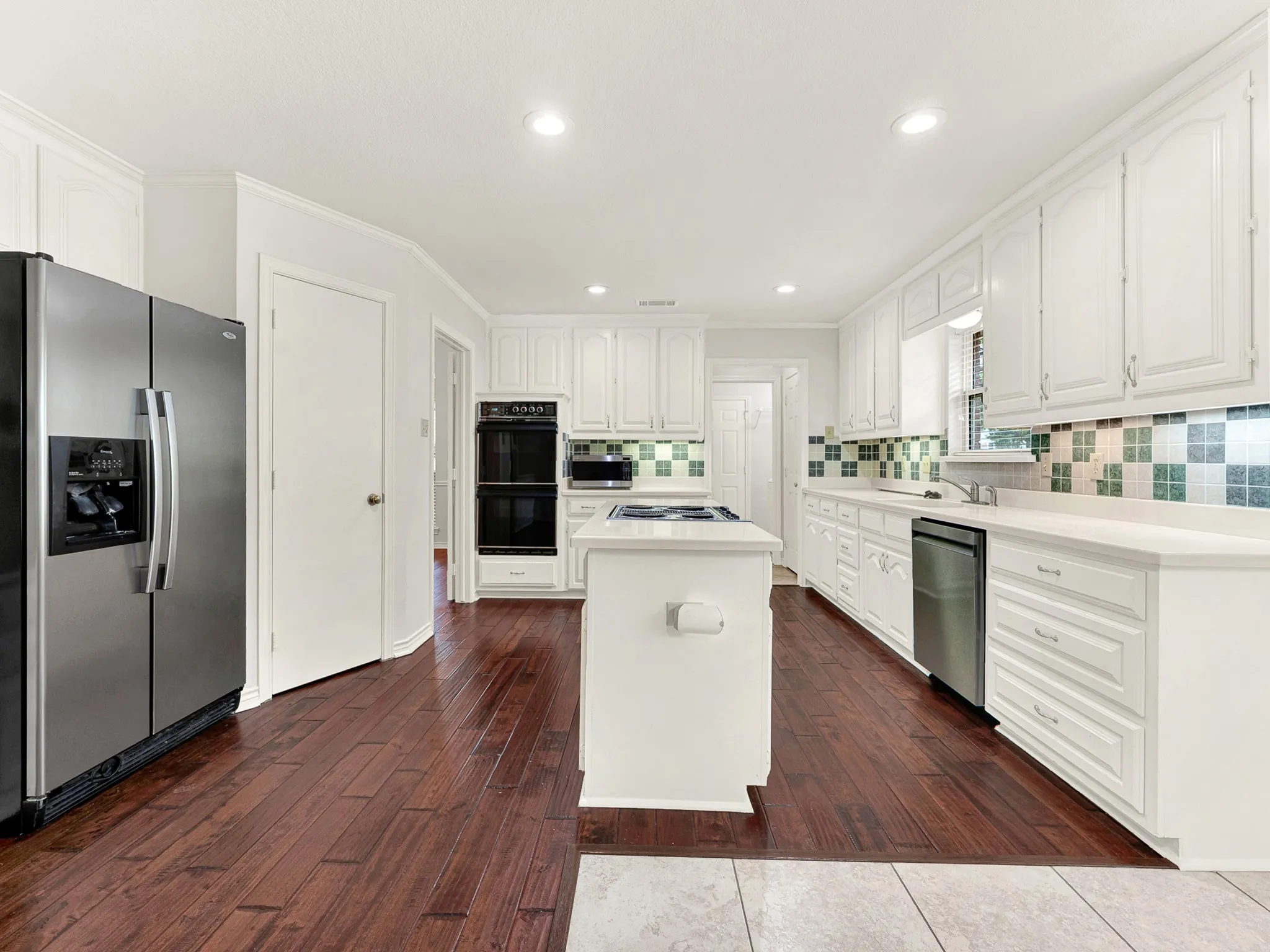 Kitchen features black and SS appliances, including double ovens