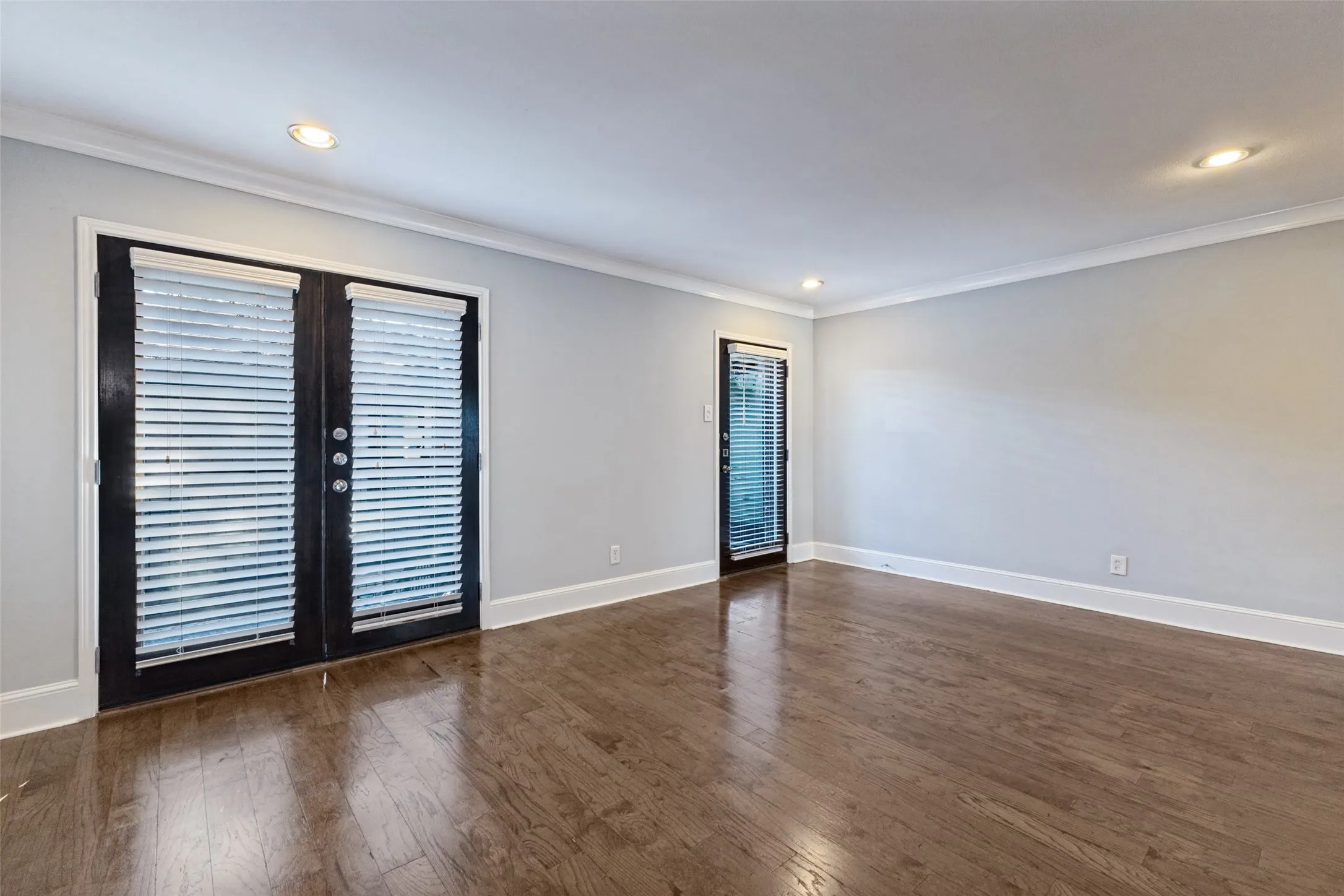 Hardwood flooring throughout, recessed lighting, crown molding, and two exterior doors with integrated blinds
