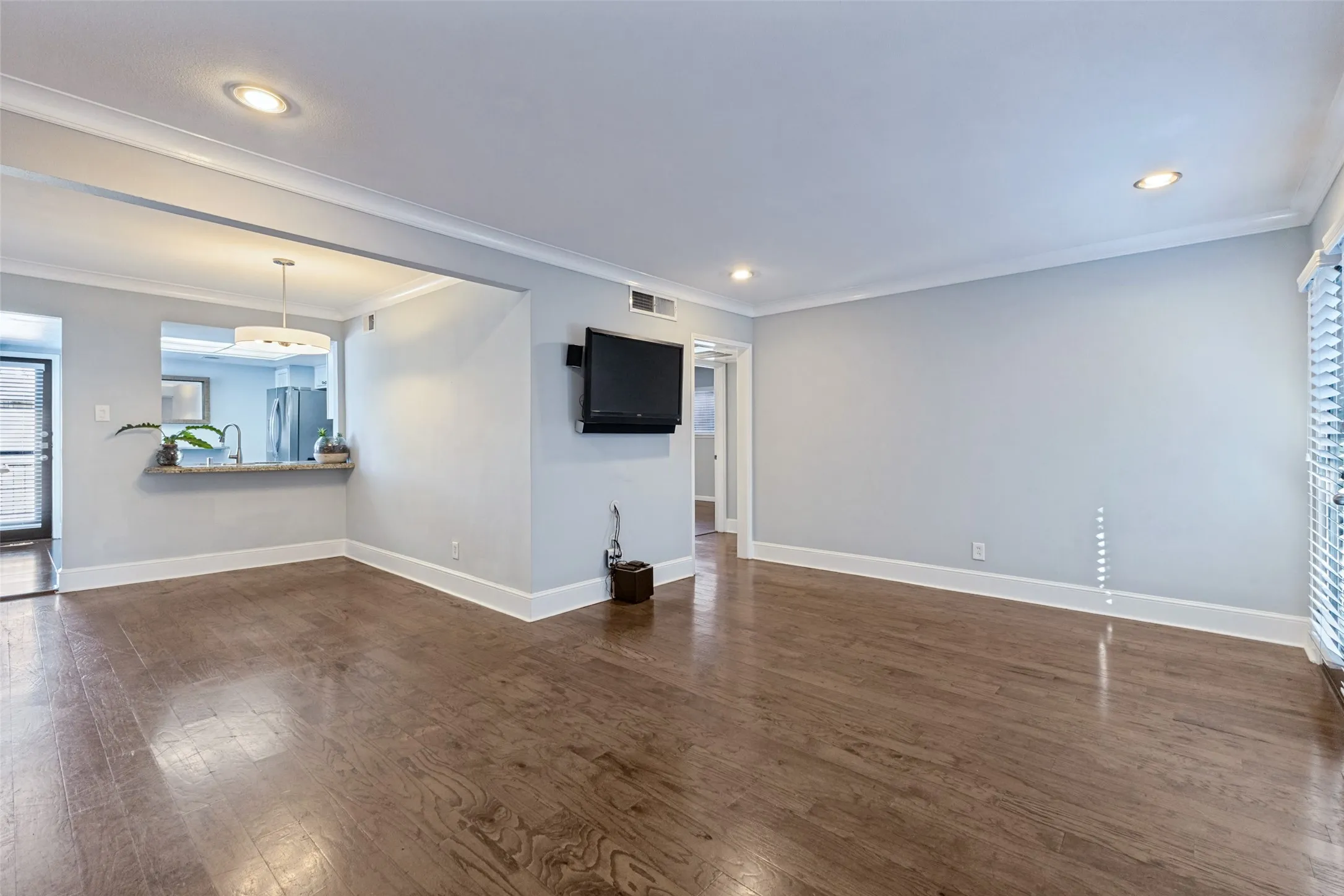 Wood-finish flooring, recessed lighting, and crown molding
