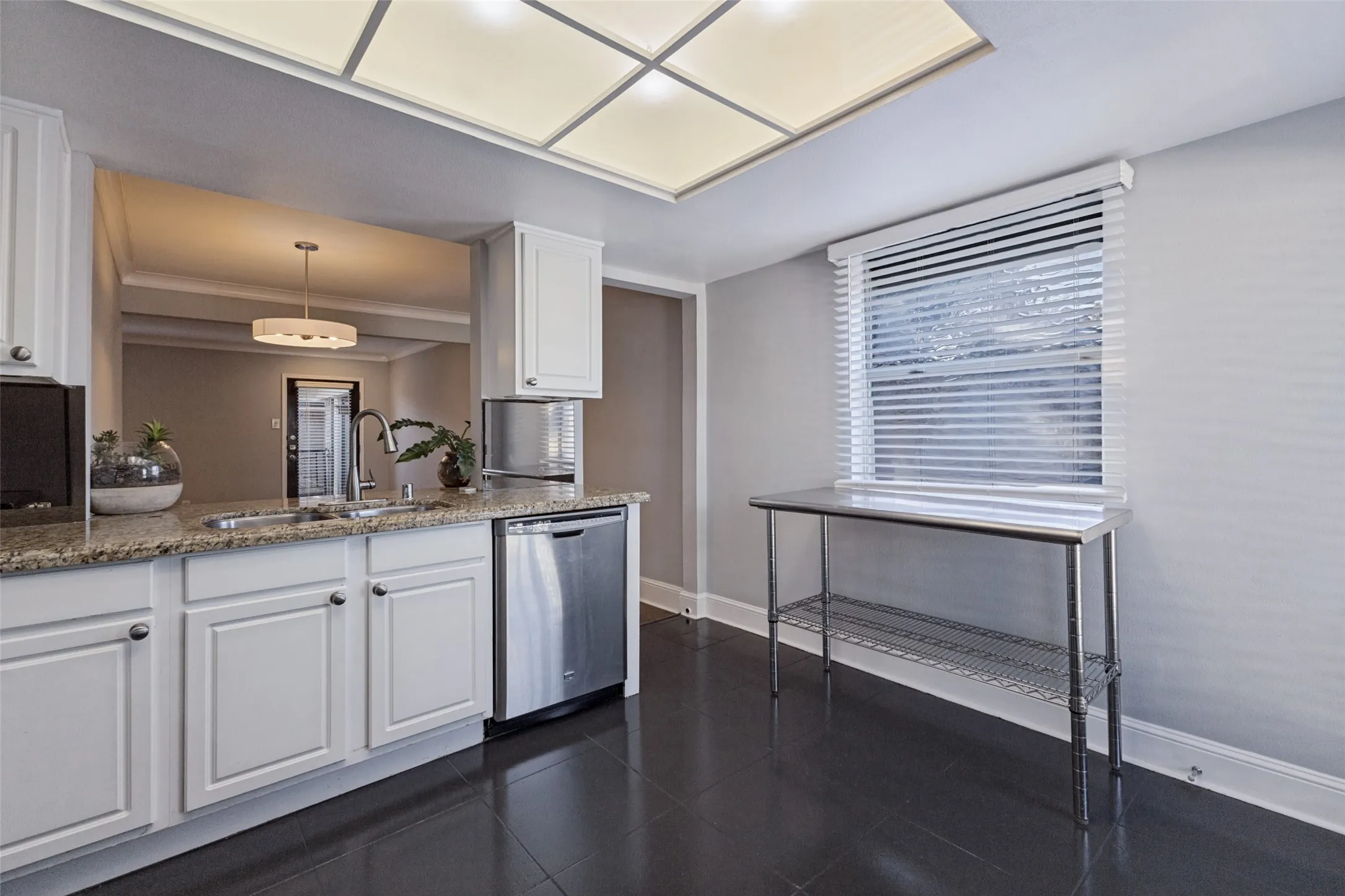 White cabinetry with stainless steel hardware, a stainless steel dishwasher, and a double basin sink
