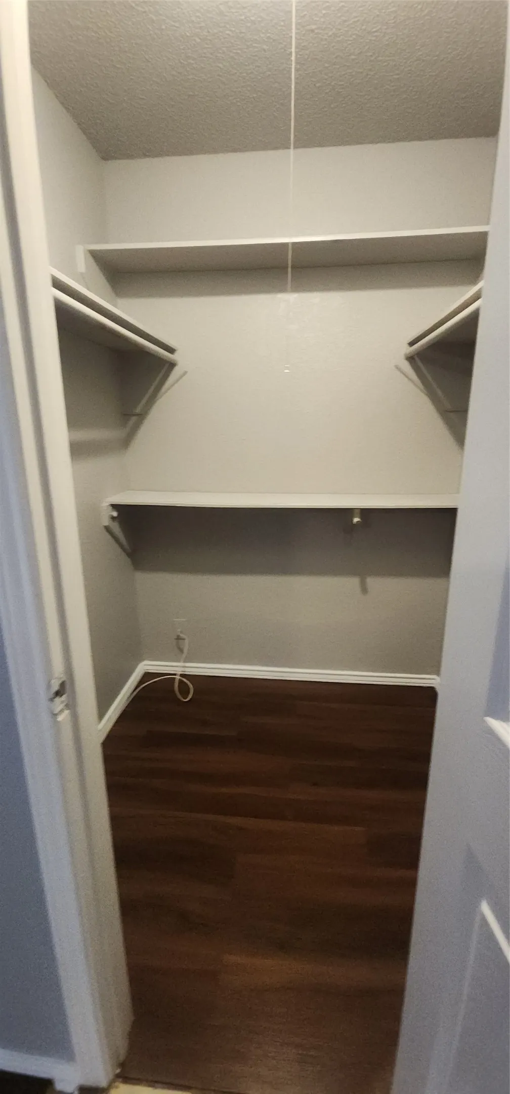 Built-in shelving with multiple levels, wood-finish flooring, and light-toned walls