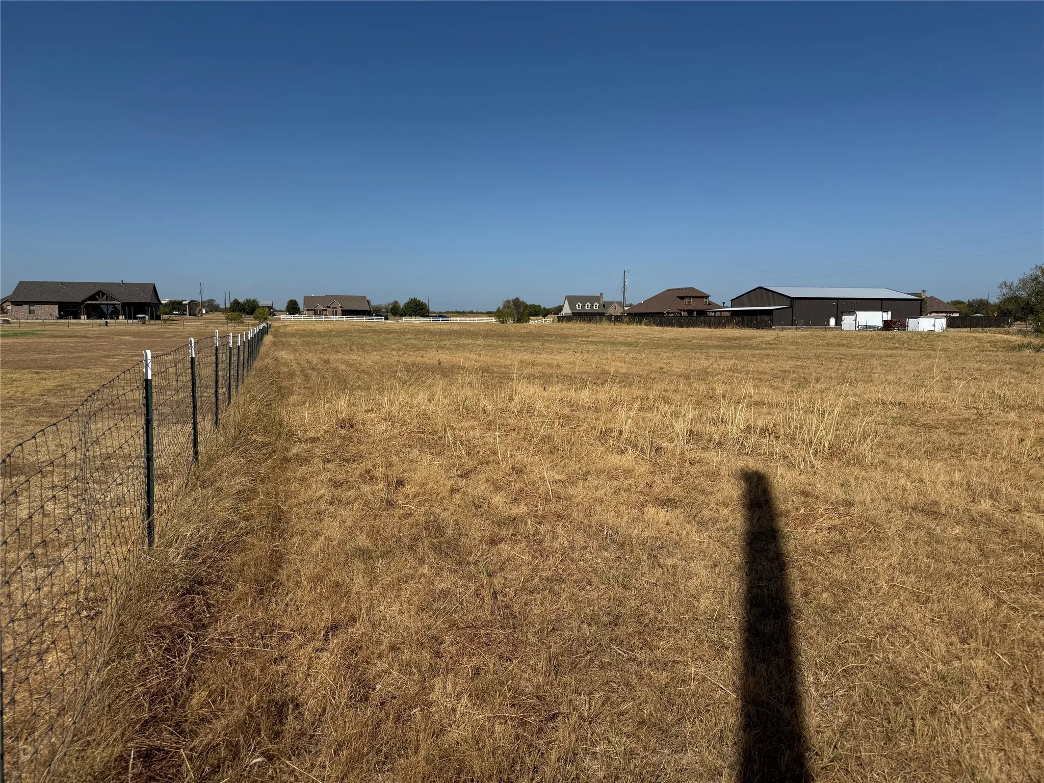 Expansive open field with perimeter fencing