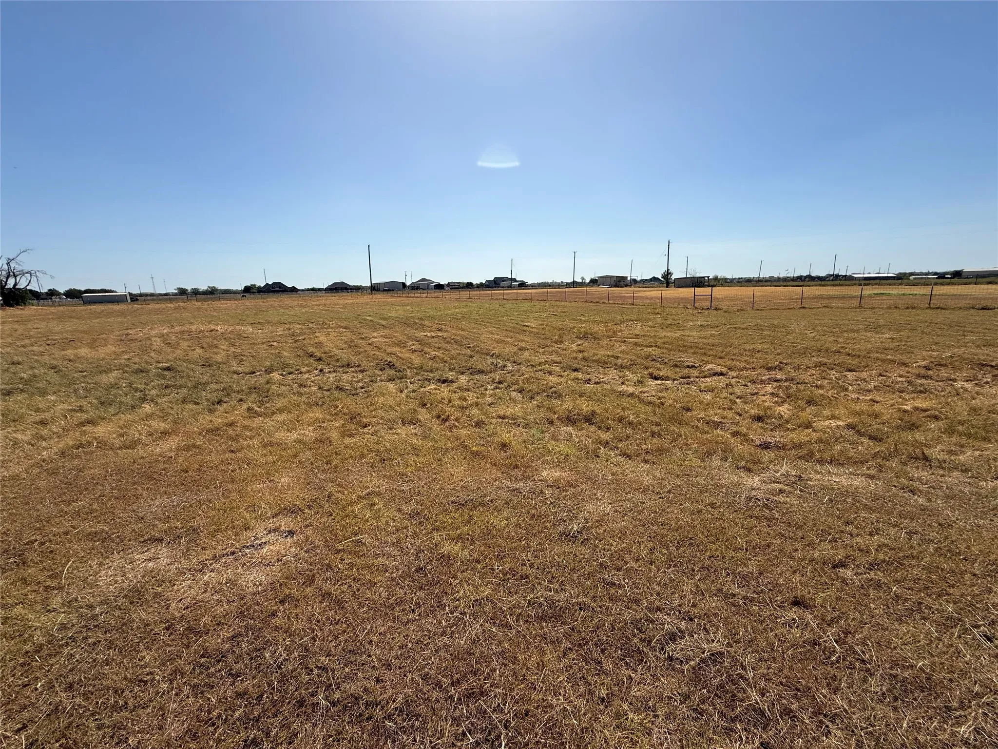 Expansive cleared lot with perimeter fencing