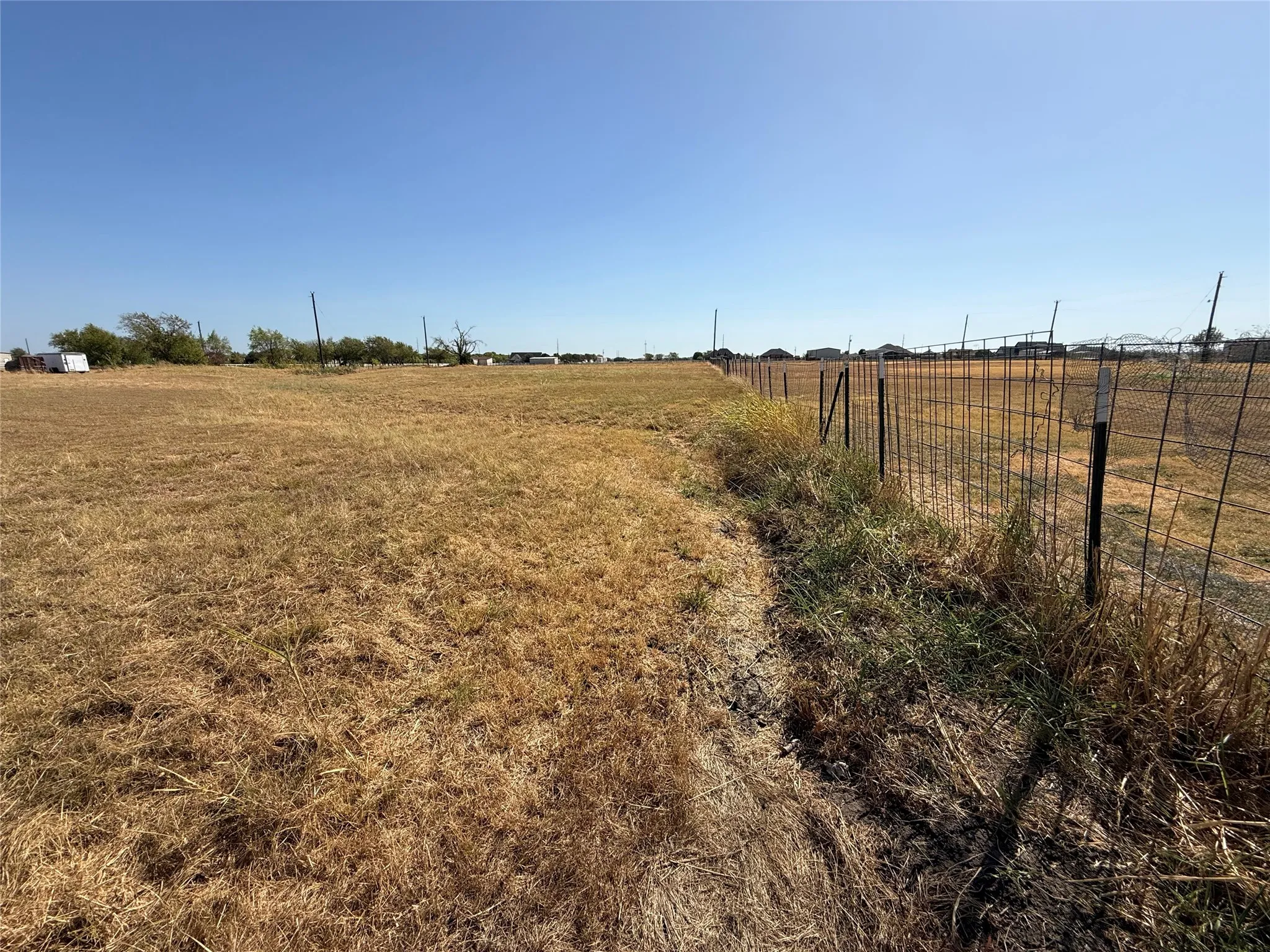Expansive land parcel featuring existing perimeter fencing and cleared ground