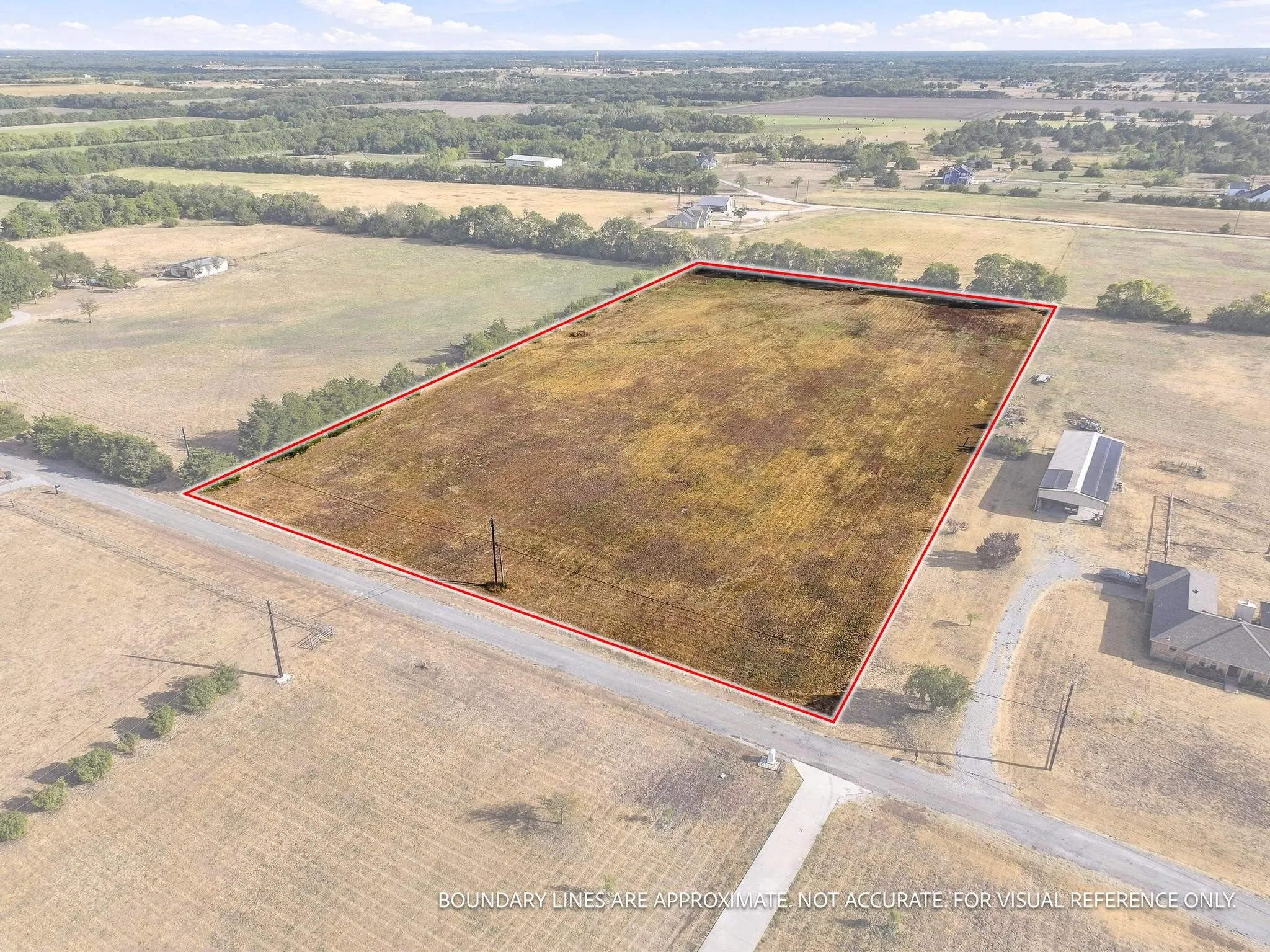 Expansive rectangular lot with clear boundaries, bordered by a single-lane road