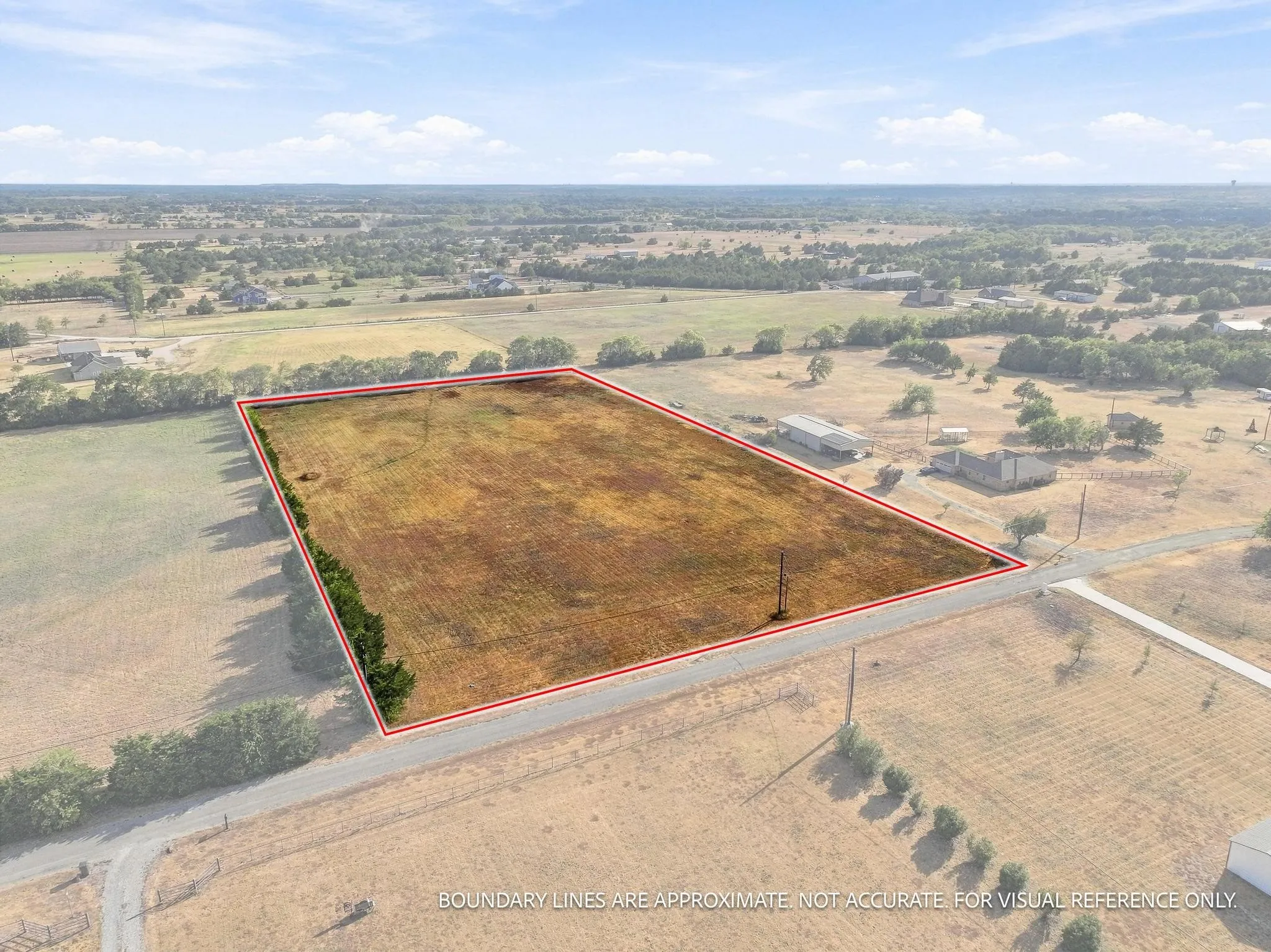 Expansive parcel featuring open land, perimeter vegetation, and road frontage