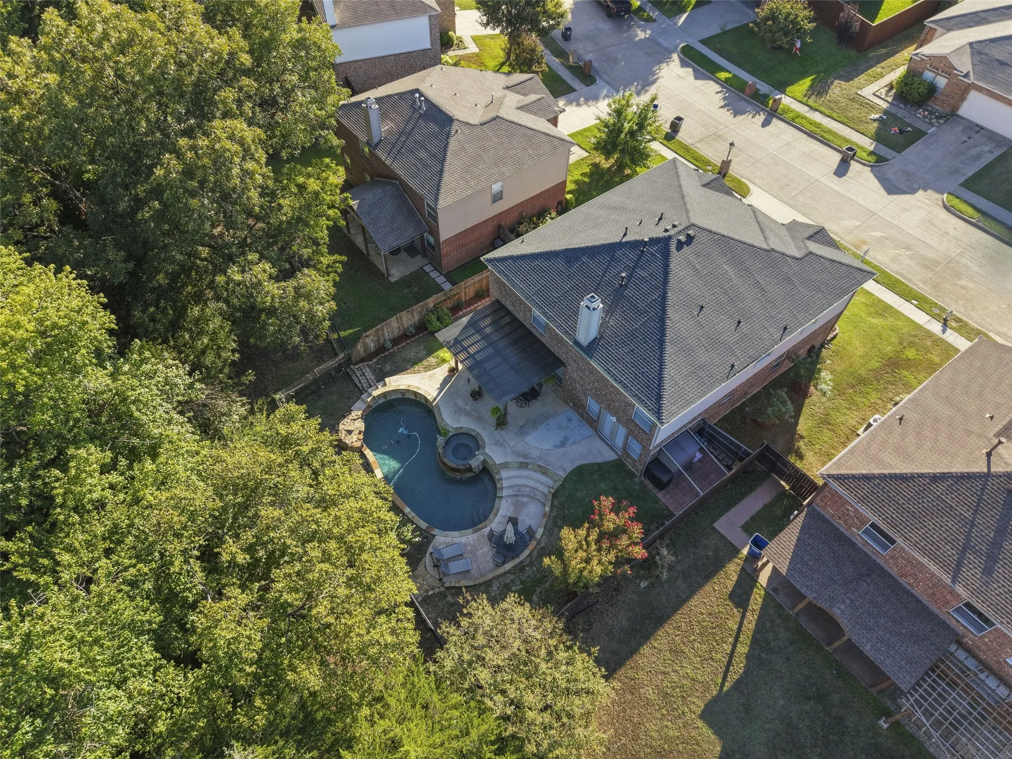 Curved swimming pool with integrated spa and stone coping