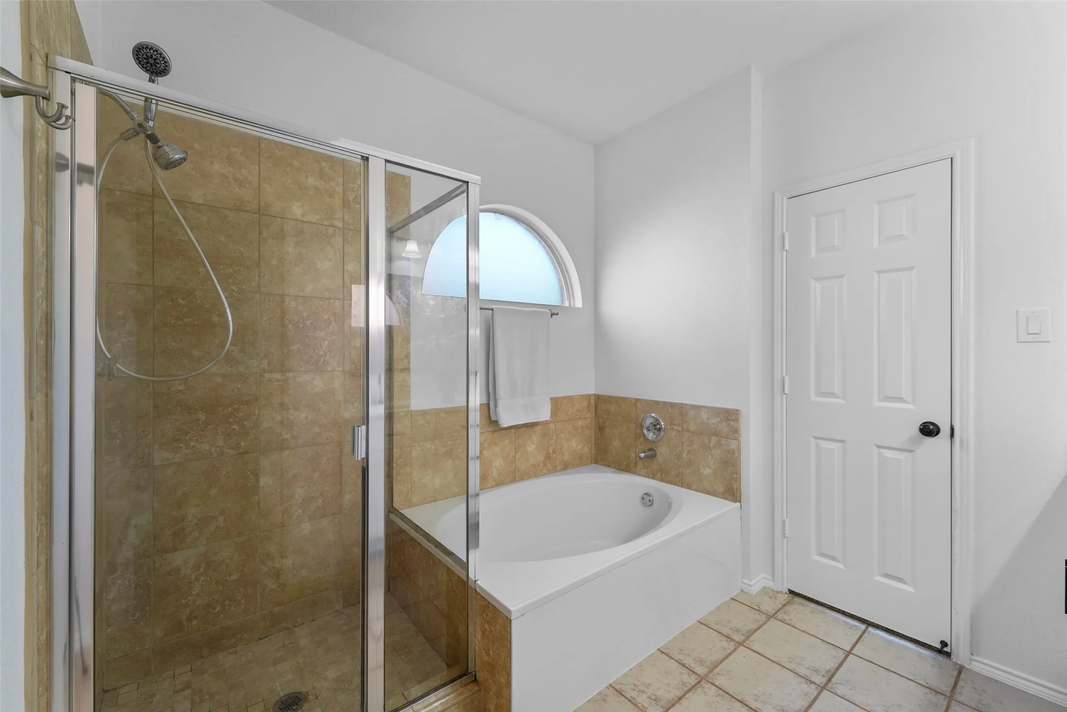 Shower with a glass enclosure, tiled walls, and a multi-function showerhead