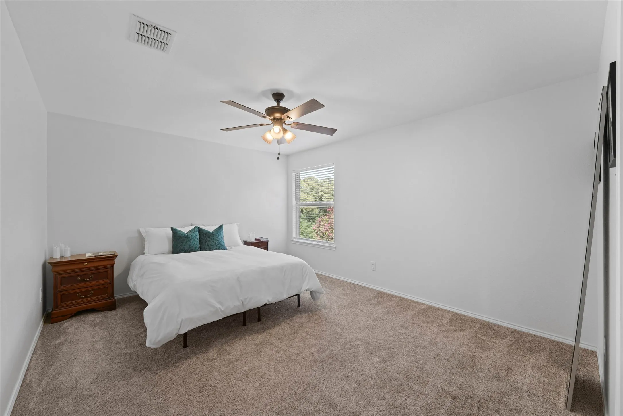 Carpeted flooring, a ceiling fan with integrated lighting, window with blinds, and white painted walls