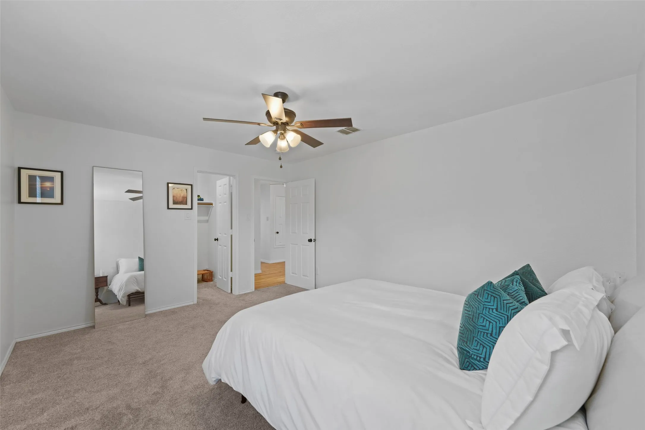 Carpeted flooring, ceiling fan with integrated lighting, and white walls
