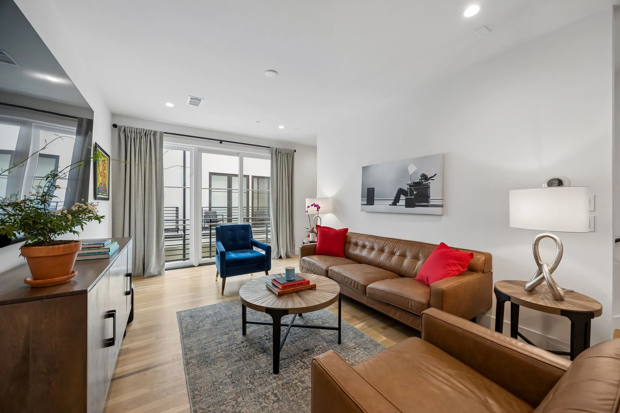 Bright and inviting living area featuring light oak wood flooring, recessed lighting, and an open floor plan filled with abundant natural light, creating an airy and welcoming atmosphere ideal for everyday living and entertaining.