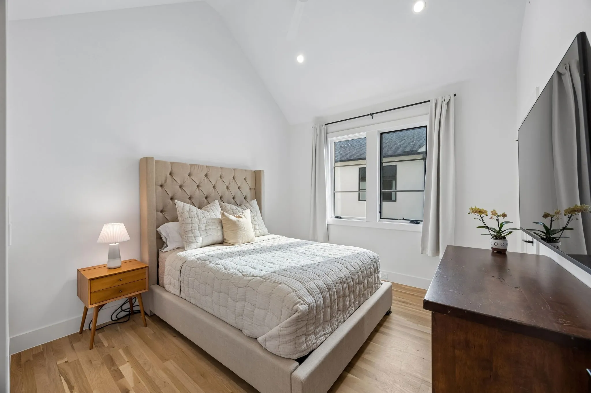 Bedroom with light wood-style floors, lofted ceiling, and recessed lighting