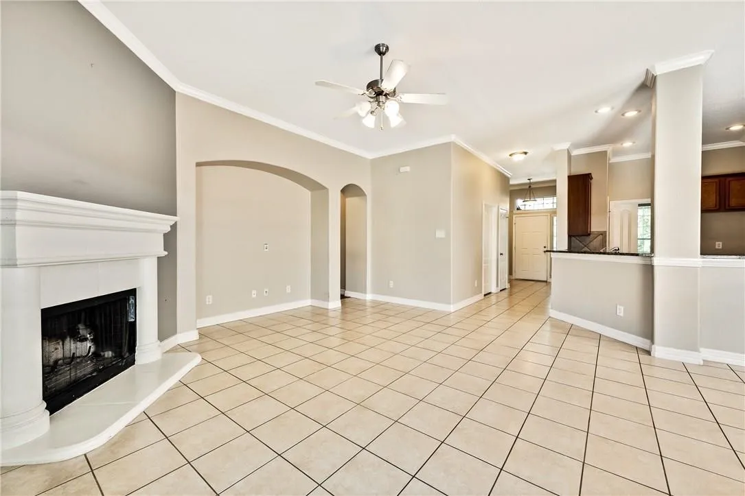 Tile flooring, vaulted ceilings, a fireplace with a stone surround, recessed lighting, and a ceiling fan